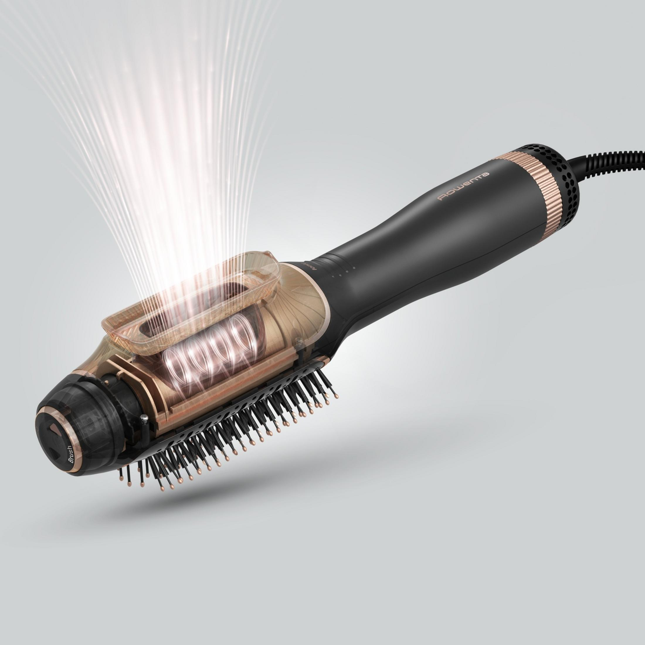 Przezroczysta suszarka do włosów z czarną rączką i różowo-złotymi detalami pokazuje element grzewczy.