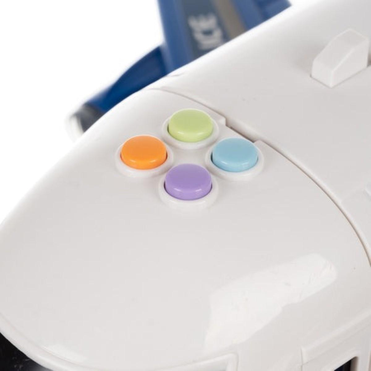 Primer plano de cuatro botones de colores en un avión de juguete blanco.