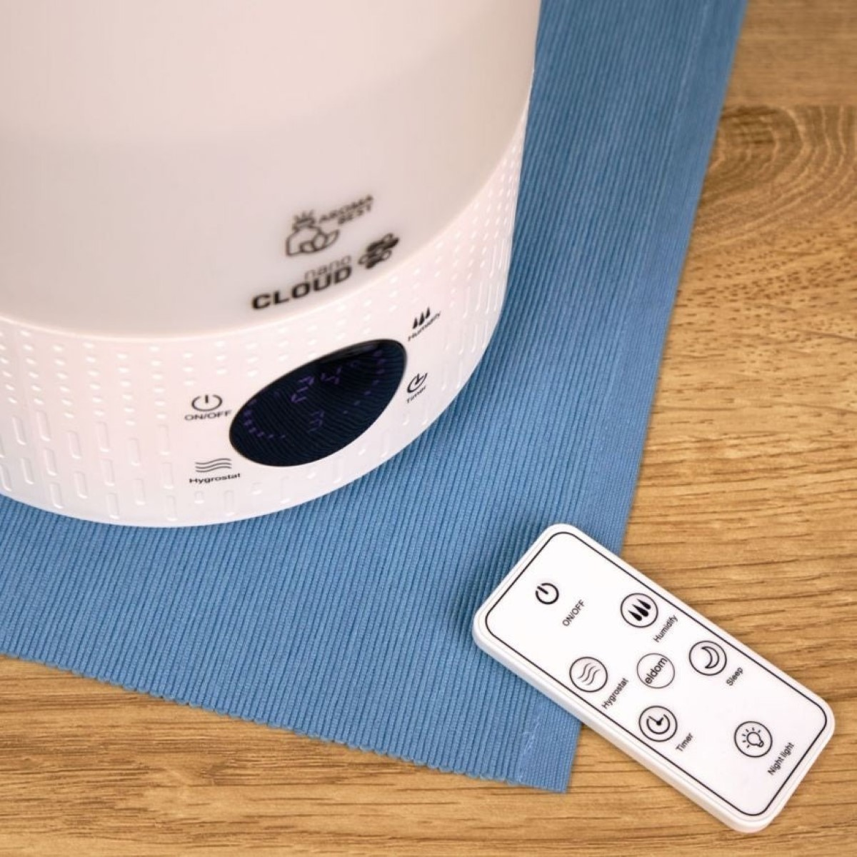 Un umidificatore bianco con telecomando su un tappetino blu.