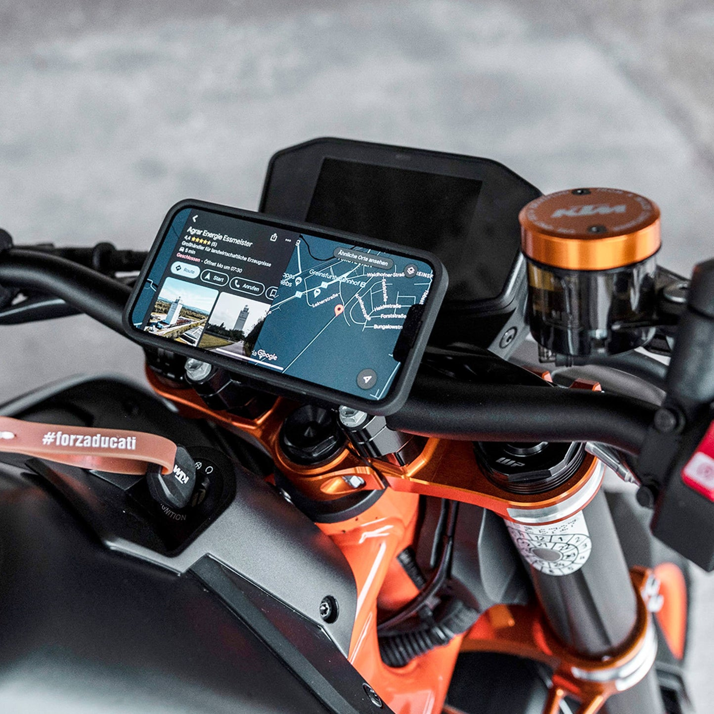 Motorradlenker mit Handyhalterung, Navigations-App wird angezeigt.