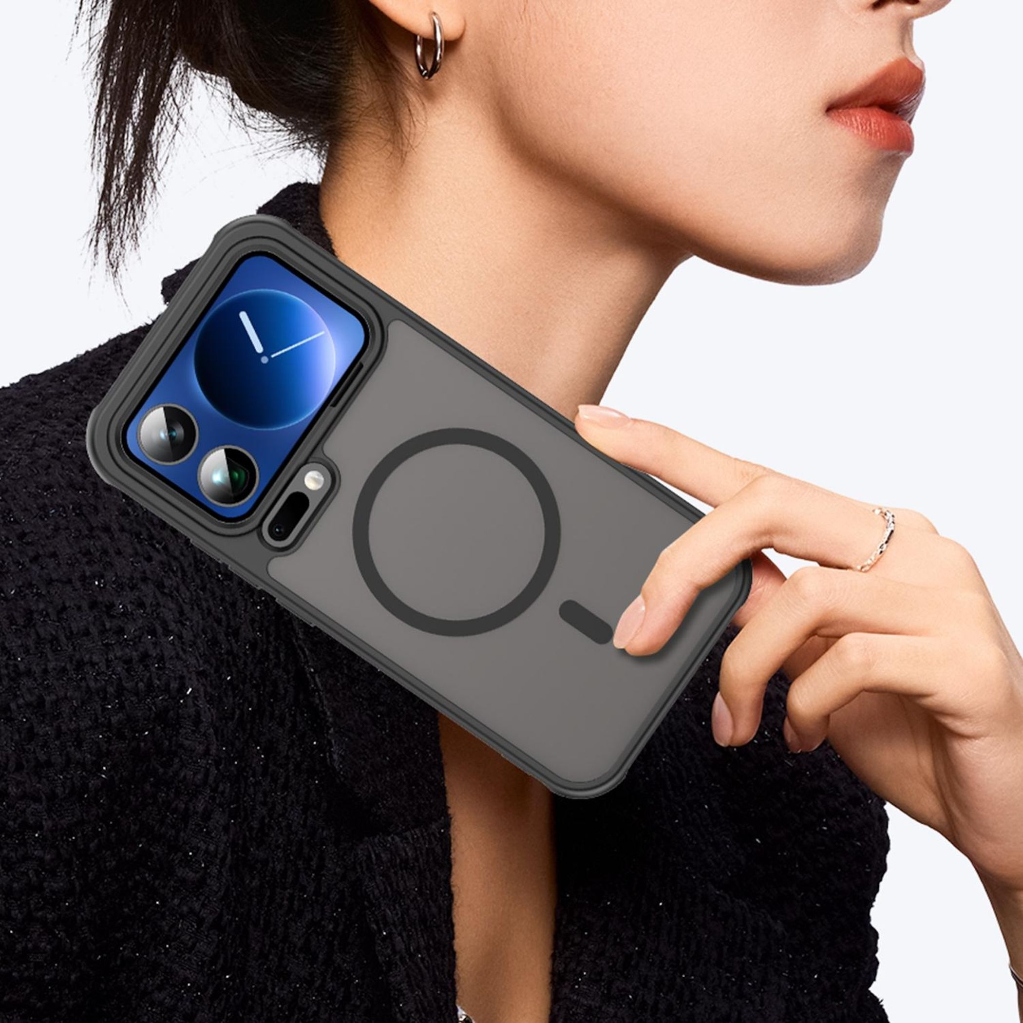 Eine Frau mit einem grauen Handy-Case mit magnetischem Kreis. Schwarzes Outfit.