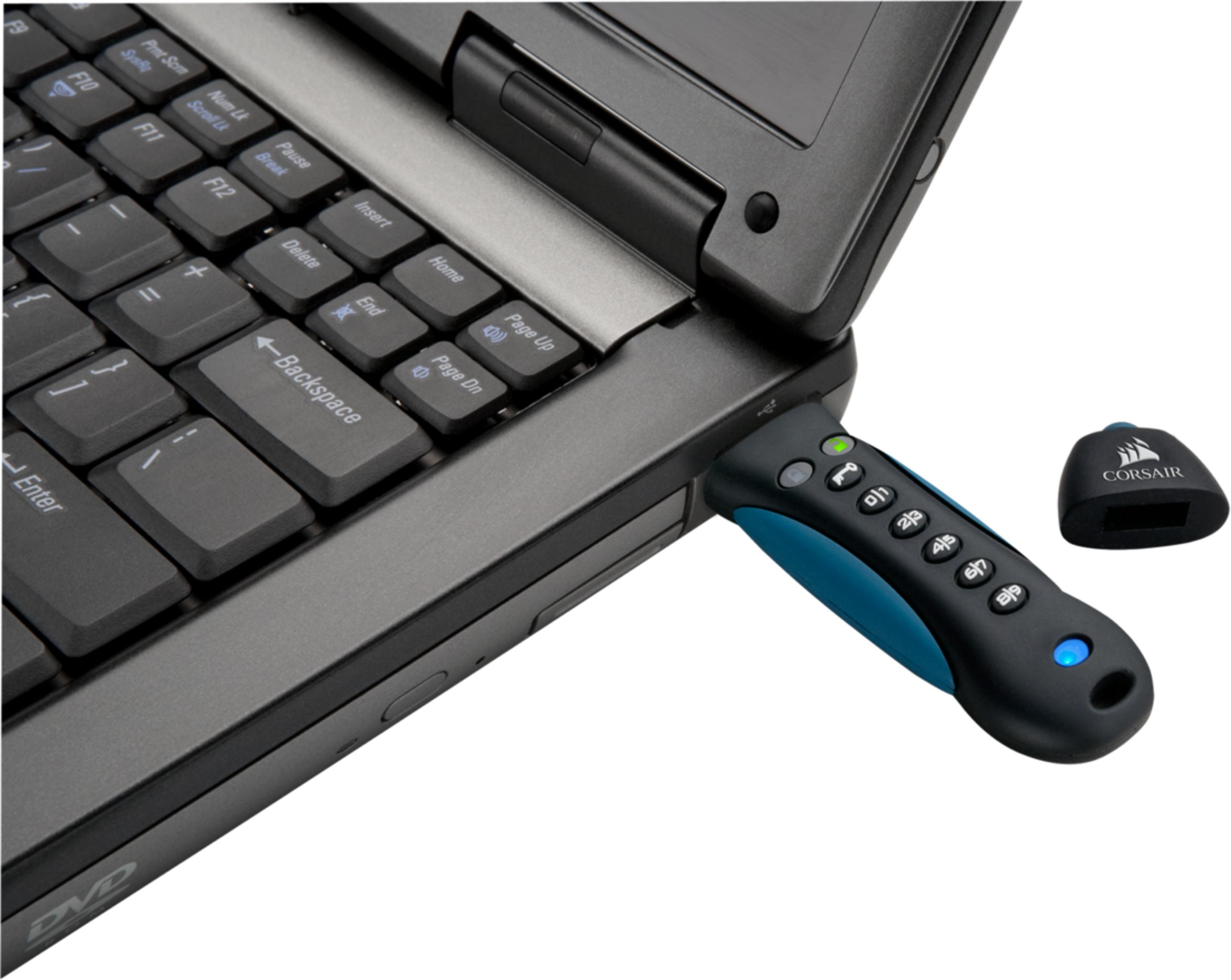 Pendrive z przyciskami i laptop z klawiaturą. Niebieski pendrive jest podłączony do laptopa.