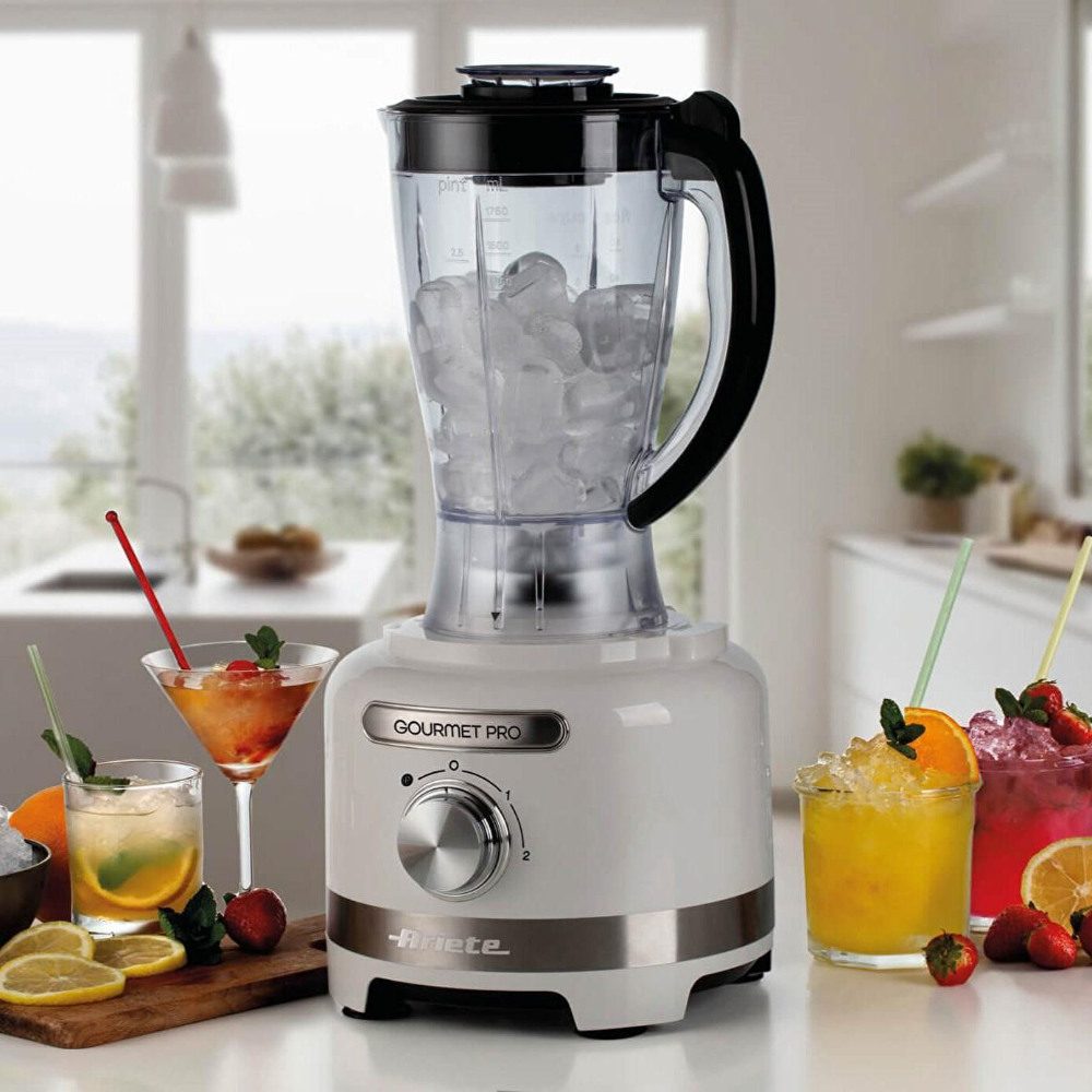 Buzla dolu beyaz blender, kokteyller ve meyvelerin yanında.