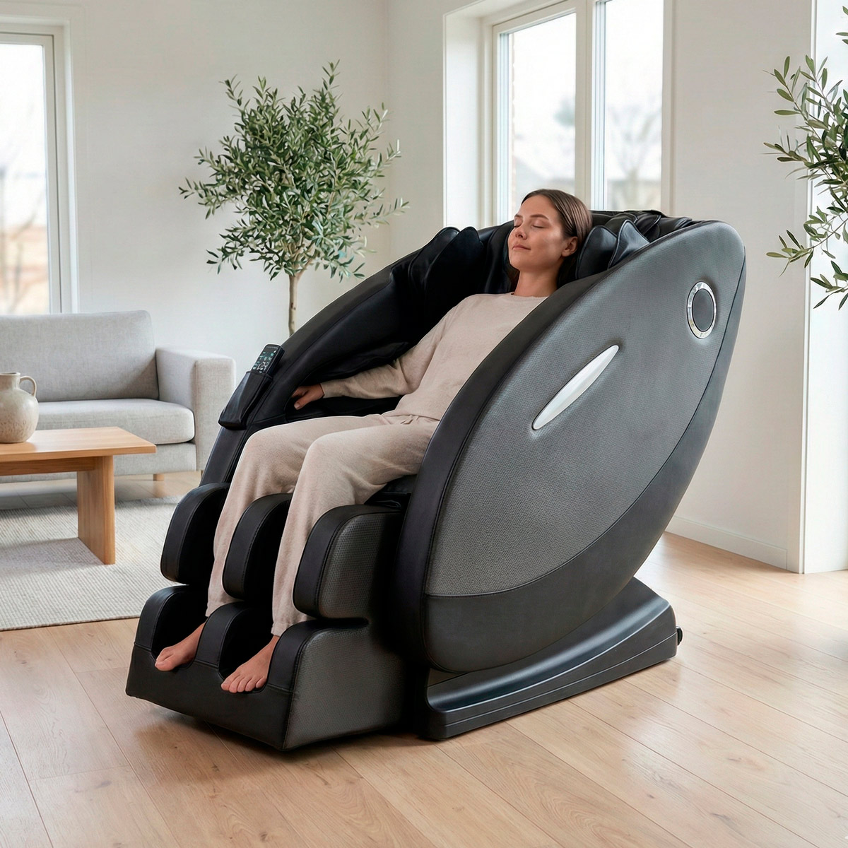 Eine Frau entspannt sich in einem großen, schwarzen Massagesessel in einem hellen Raum.