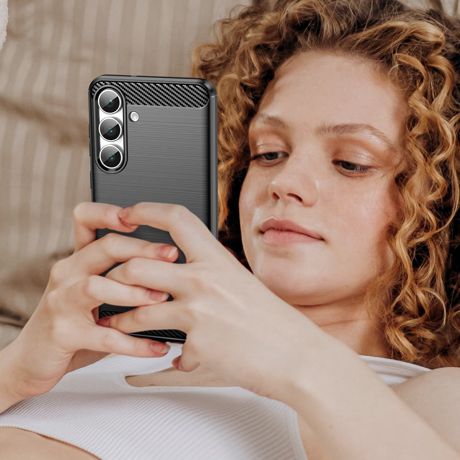 Mujer de pelo rizado sostiene un smartphone con tres cámaras.
