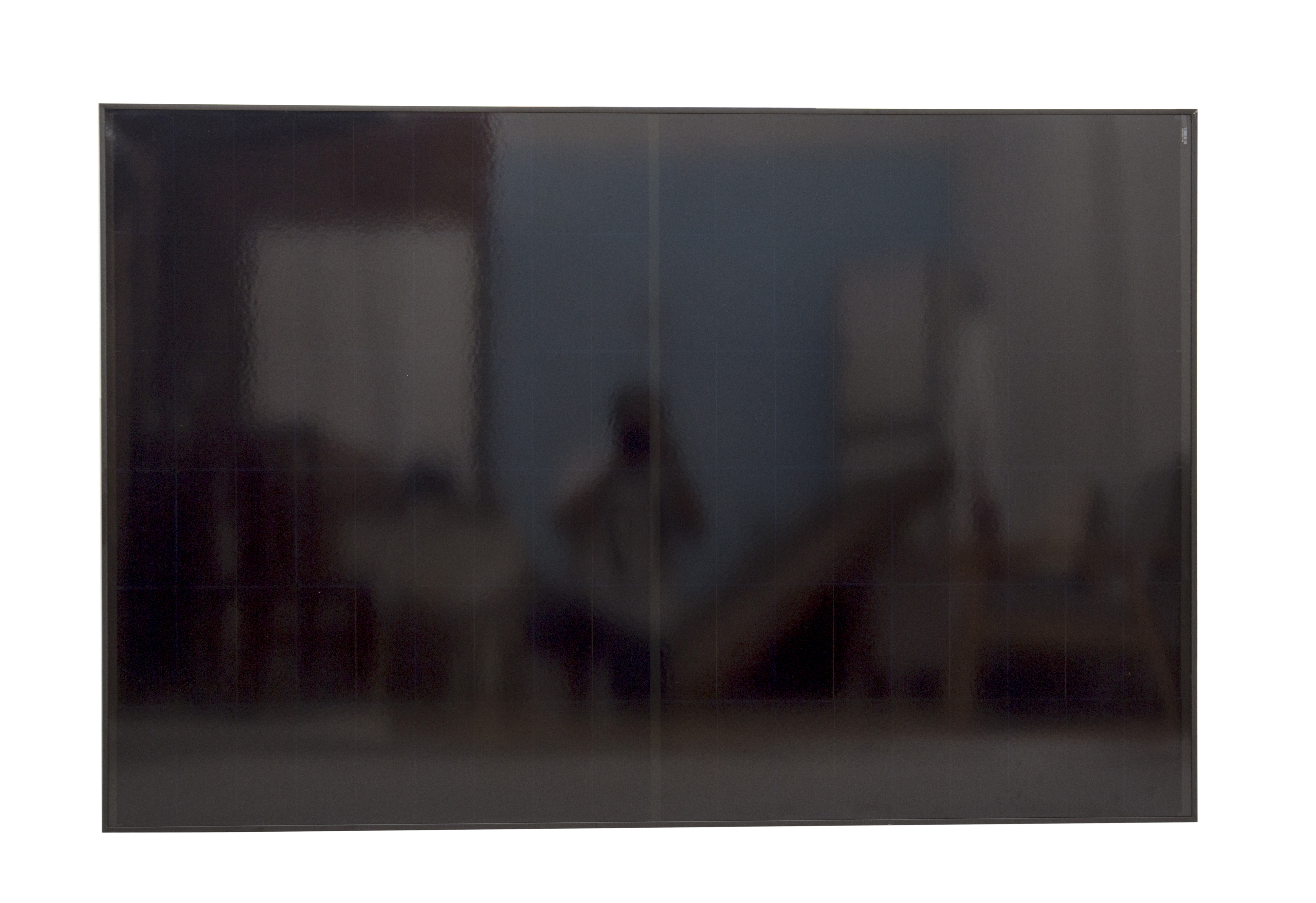 Schwarzes Solarpanel mit sichtbaren Reflexionen von einer Person und Möbeln.