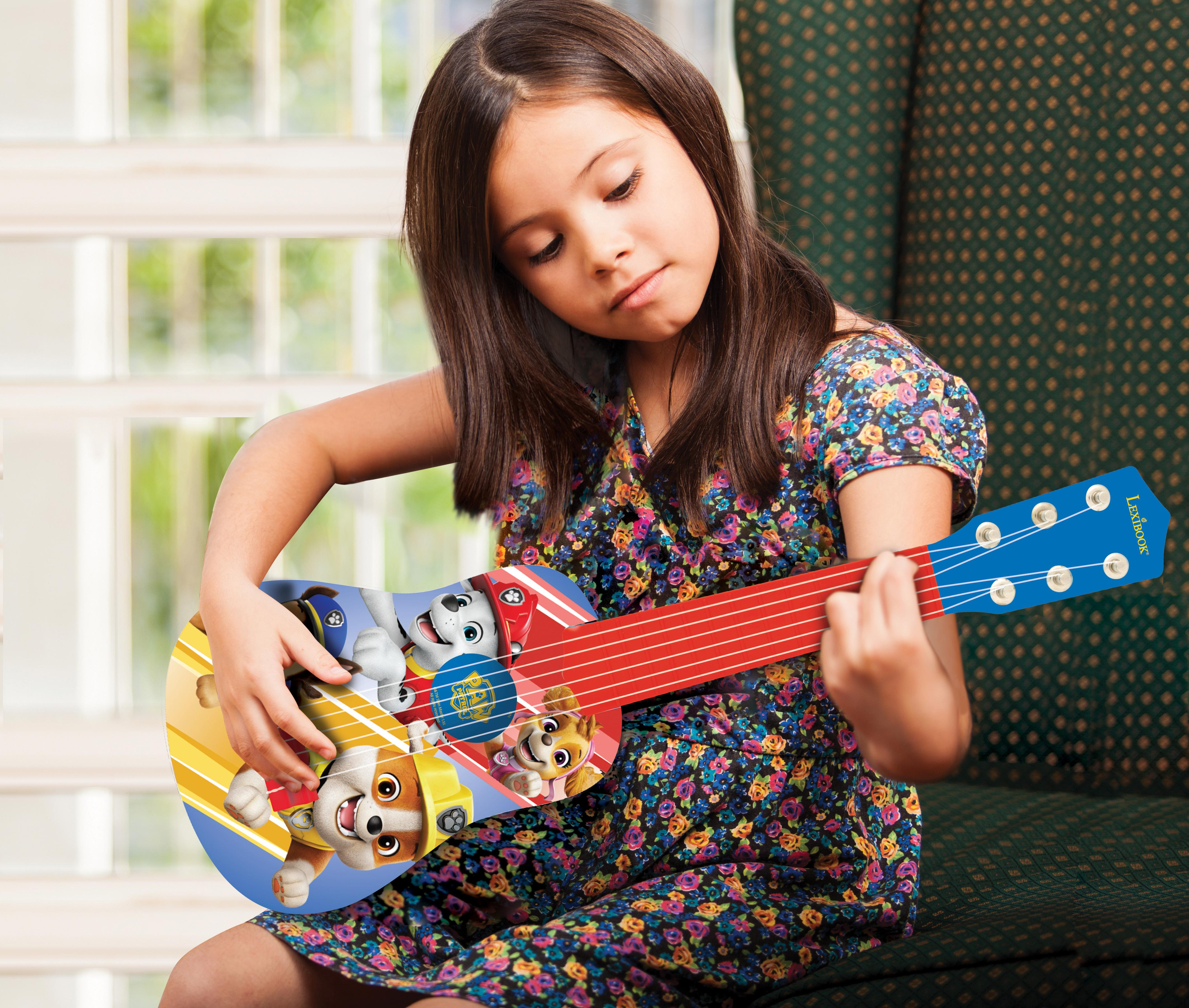 Dziewczynka gra na gitarze z postaciami Psiego Patrolu, okno i zielone tło.