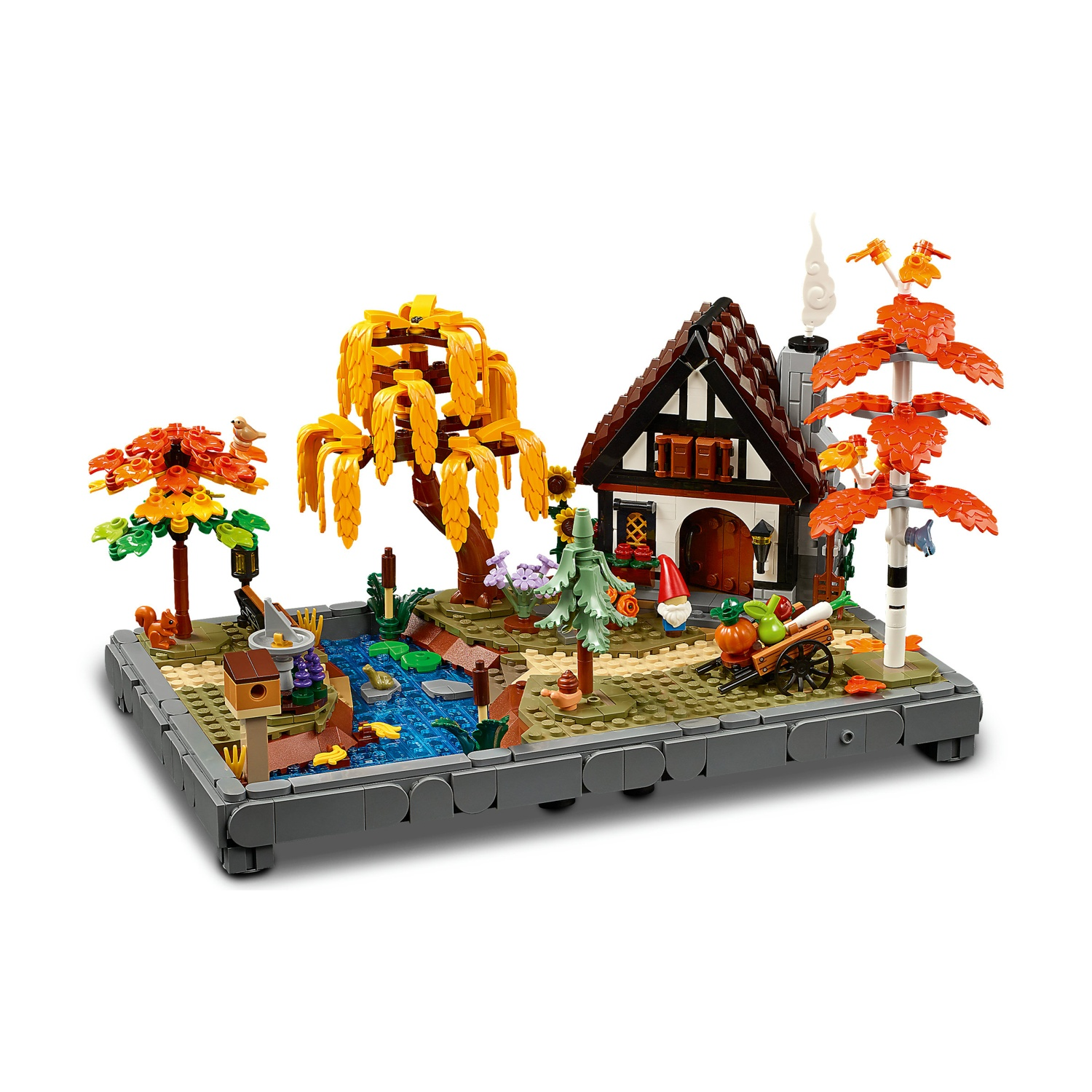 Jesienne diorama Lego z domem, stawem, drzewami i wózkiem.