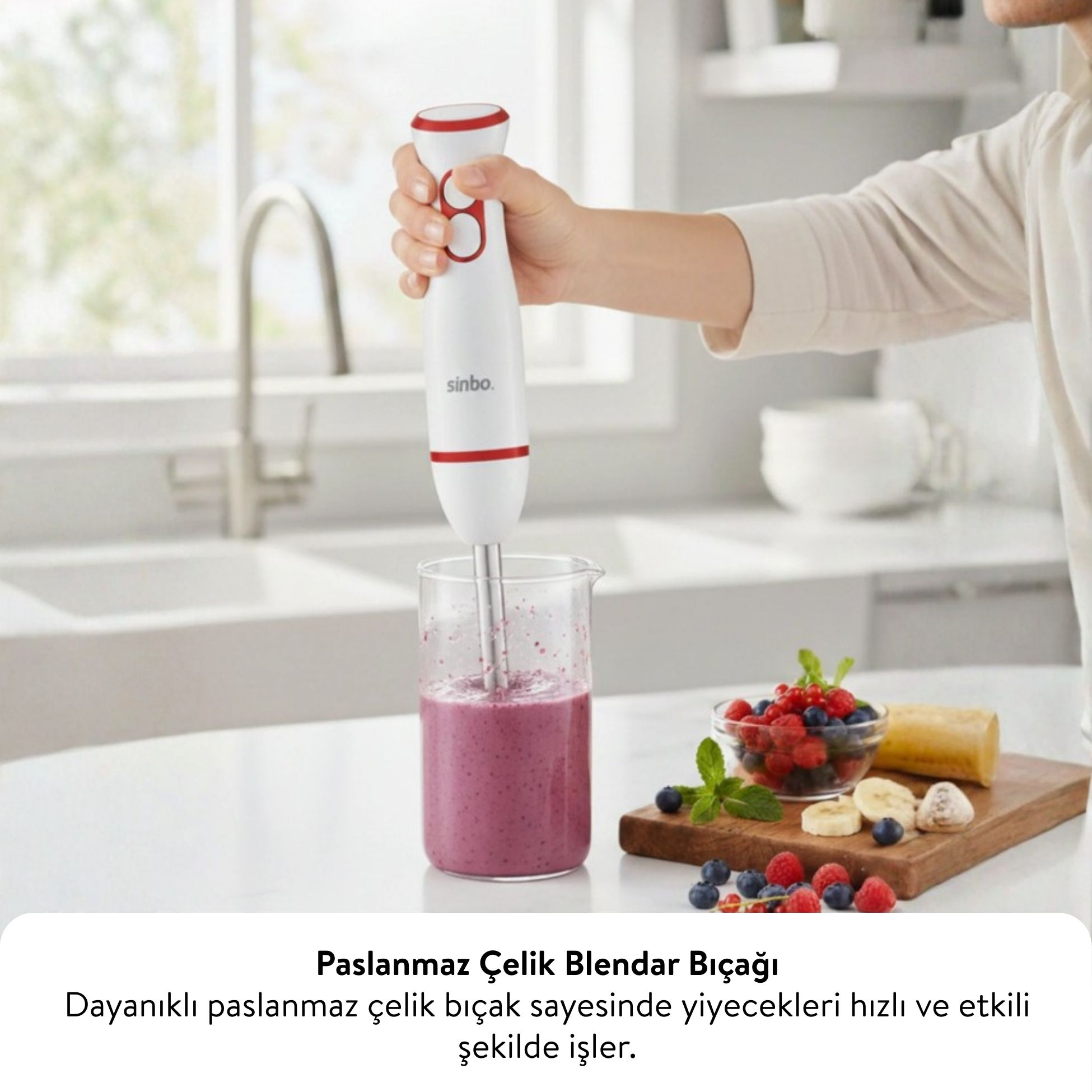 Bir el, böğürtlenli smoothie bardağının üzerinde beyaz bir el blenderı tutuyor.