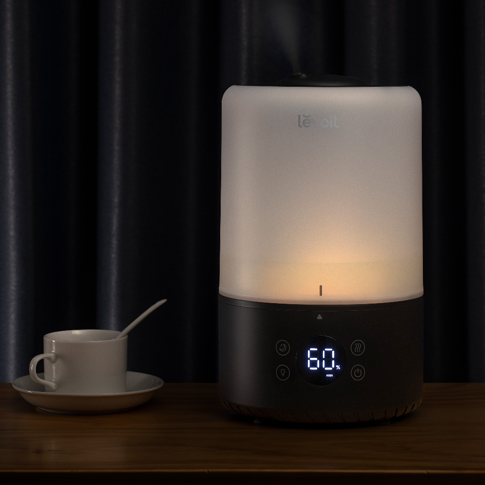 Nawilżacz Levoit z cyfrowym wyświetlaczem na drewnianym stole.