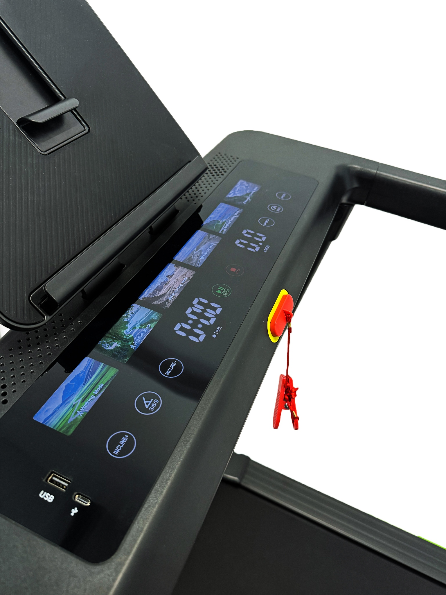 Zbliżenie na wyświetlacz bieżni z trybami i portami USB. Czerwony klips bezpieczeństwa.