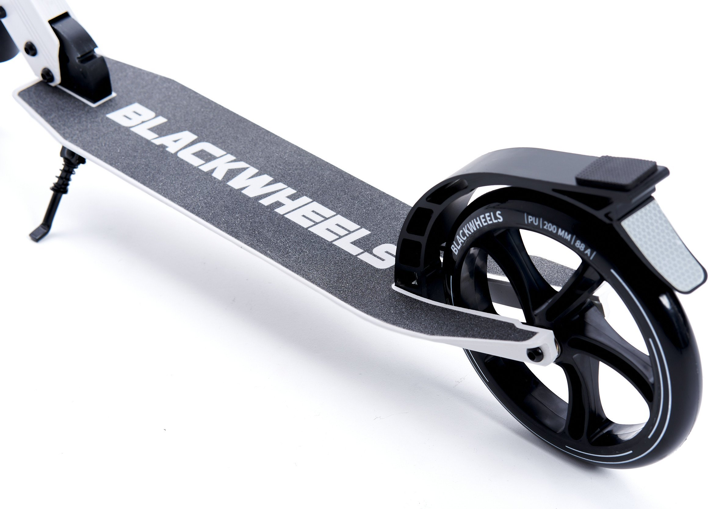 Primer plano de un patinete negro con texto "BLACKWHEELS" blanco en la cubierta.
