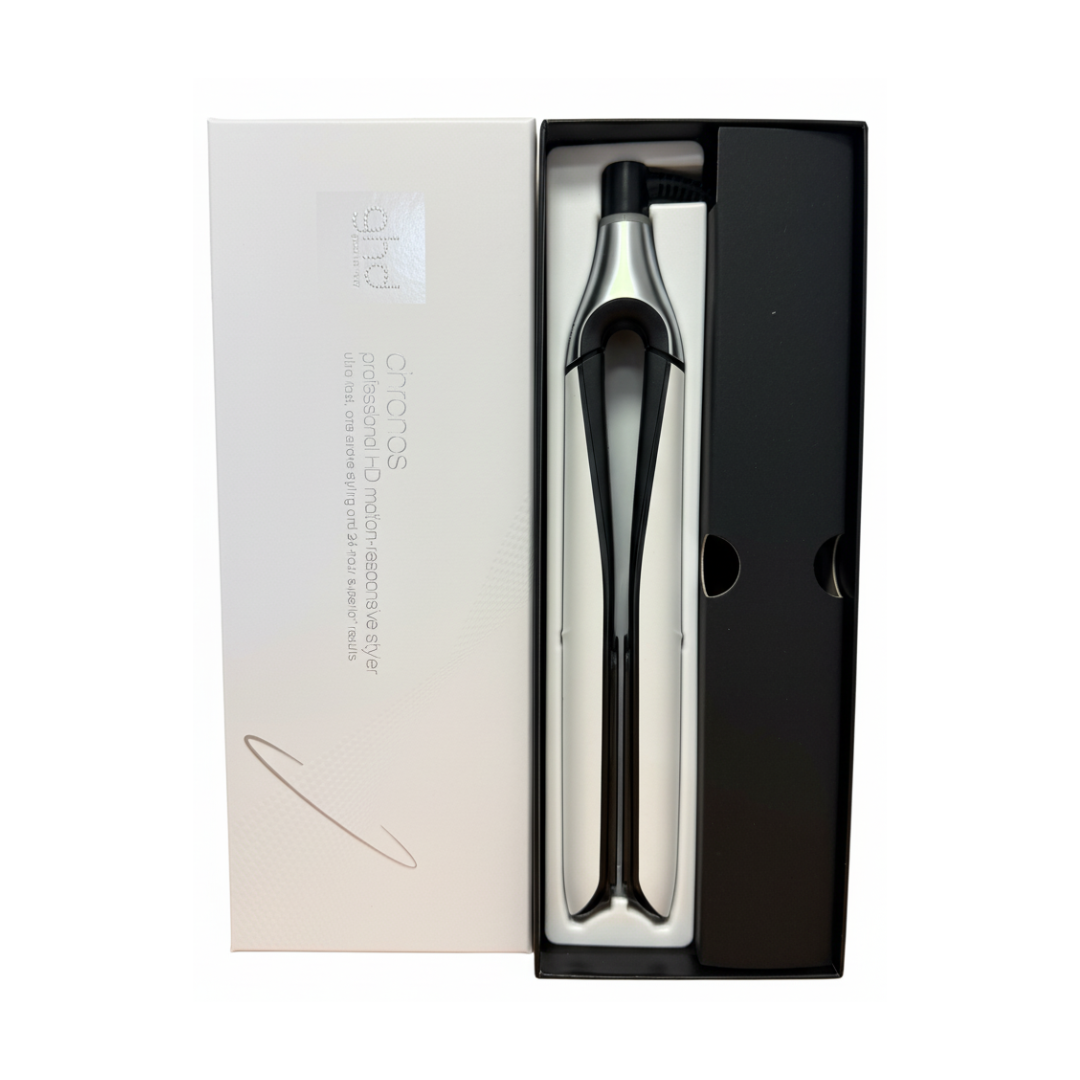 Ein silberner Haarstyler in einer schwarzen Box, daneben eine weiße Verpackung.