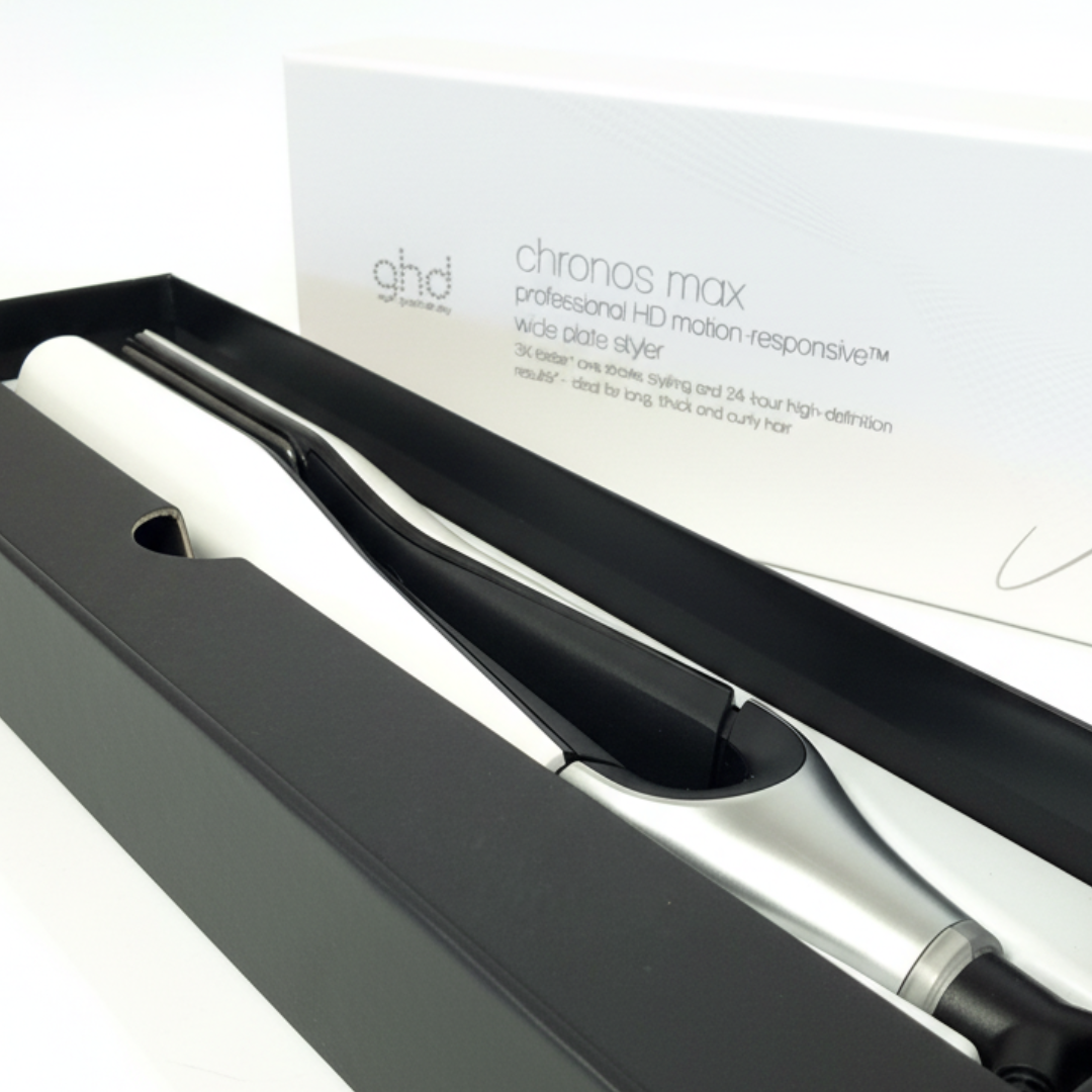 Ein schwarzes und silbernes Haarglätteisen in einer schwarzen Box, mit Produktbeschreibung.