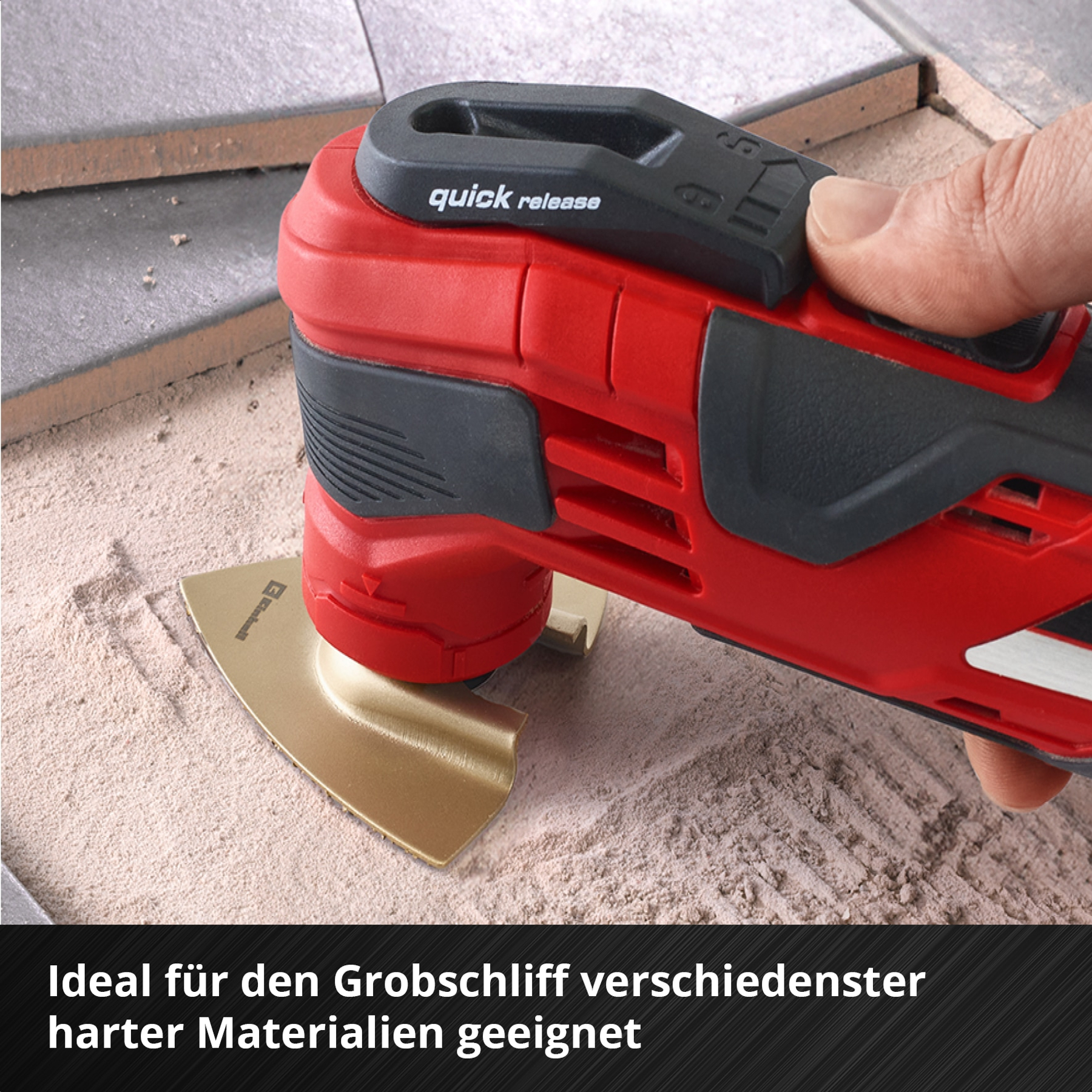 Ein rotes Multifunktionswerkzeug mit goldenem Sägeblatt auf Sand.