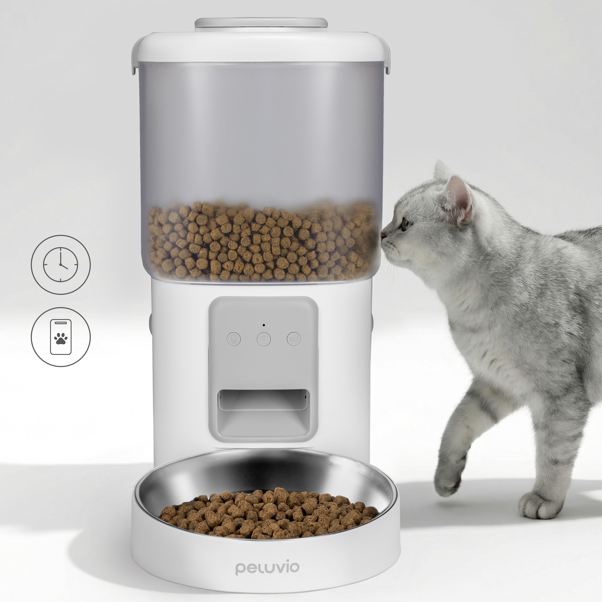 Eine graue Katze nähert sich einem weißen Futterautomaten mit Futter.