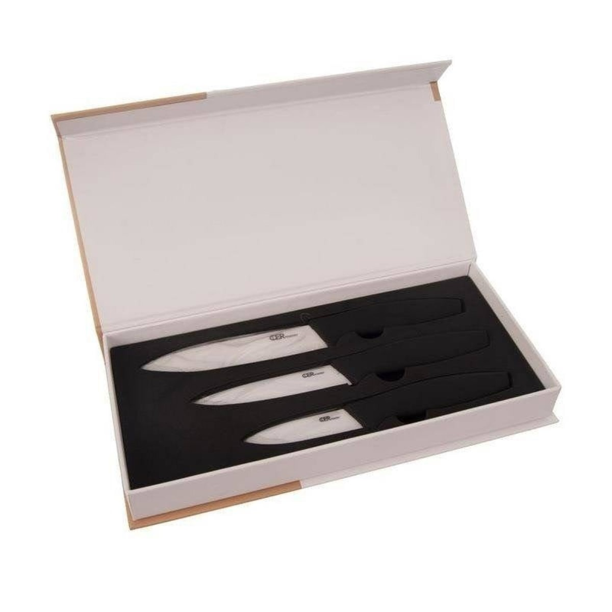 Un juego de cuatro cuchillos de cerámica blancos en una caja de regalo negra abierta.