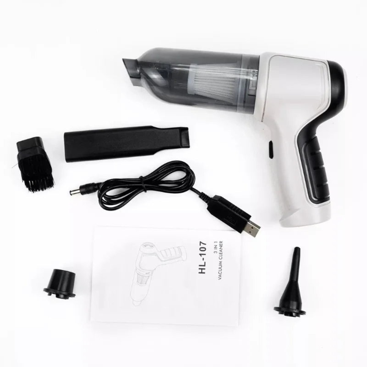 Una aspiradora de mano blanca y negra con accesorios, cable y manual.