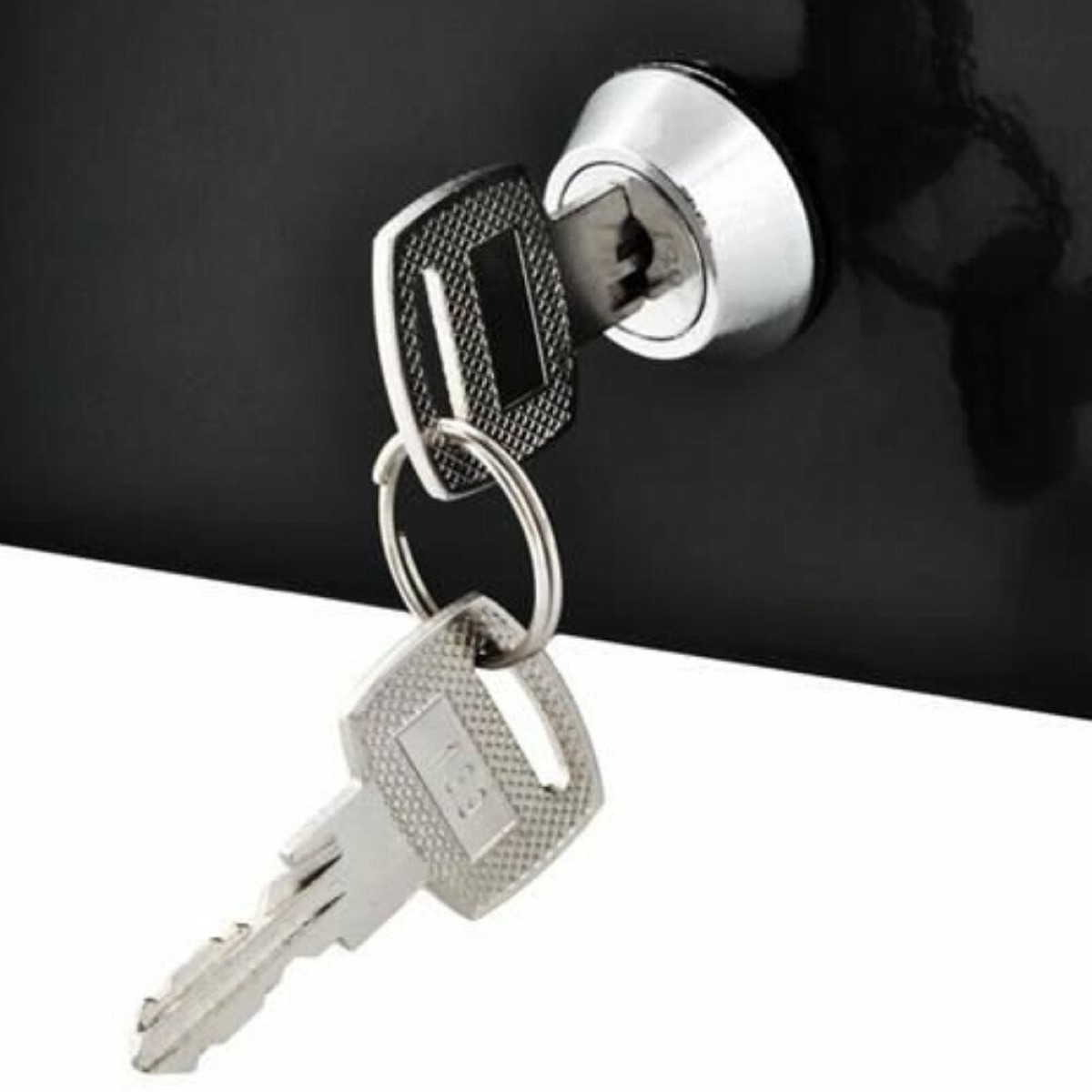 Una llave en una cerradura, otra cuelga del anillo.