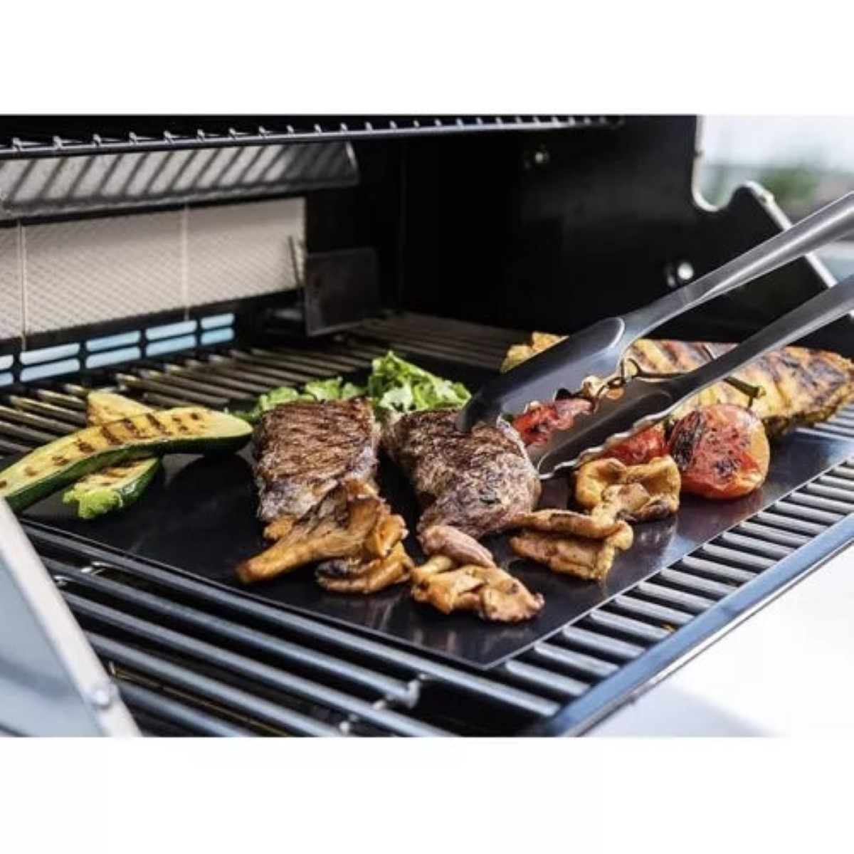 Carne y verduras a la parrilla sobre una alfombra. Pinzas moviendo comida en la parrilla.