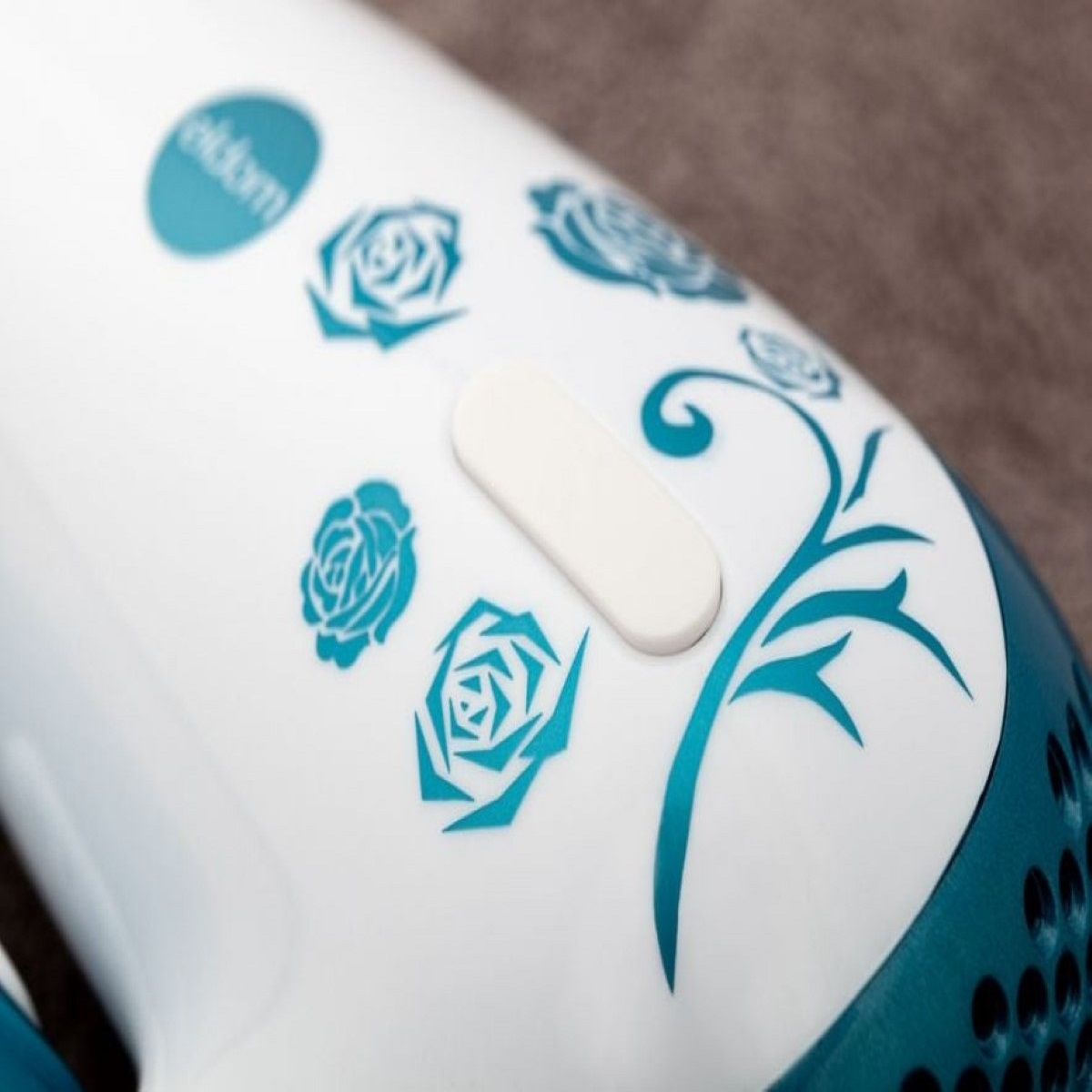 Un dispositivo bianco con rose turchesi e motivo a vite turchese.