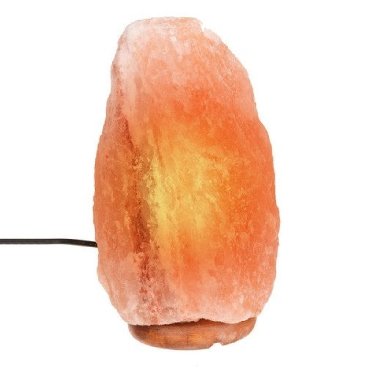 Una lámpara de sal del Himalaya iluminada sobre una base de madera.