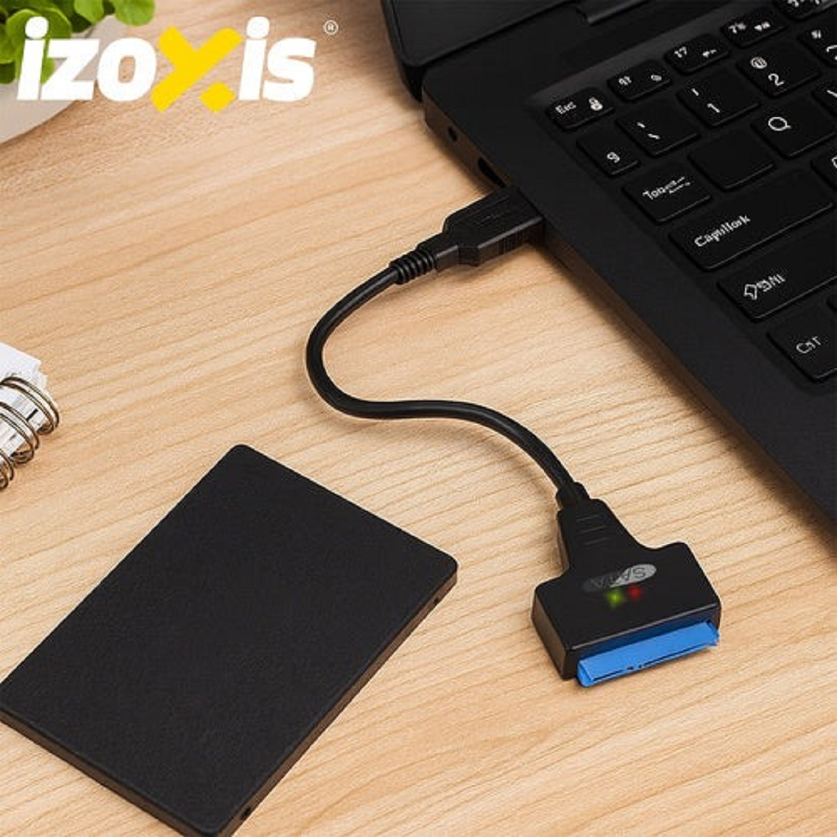 Un portátil negro está conectado a un disco duro externo mediante un cable SATA.