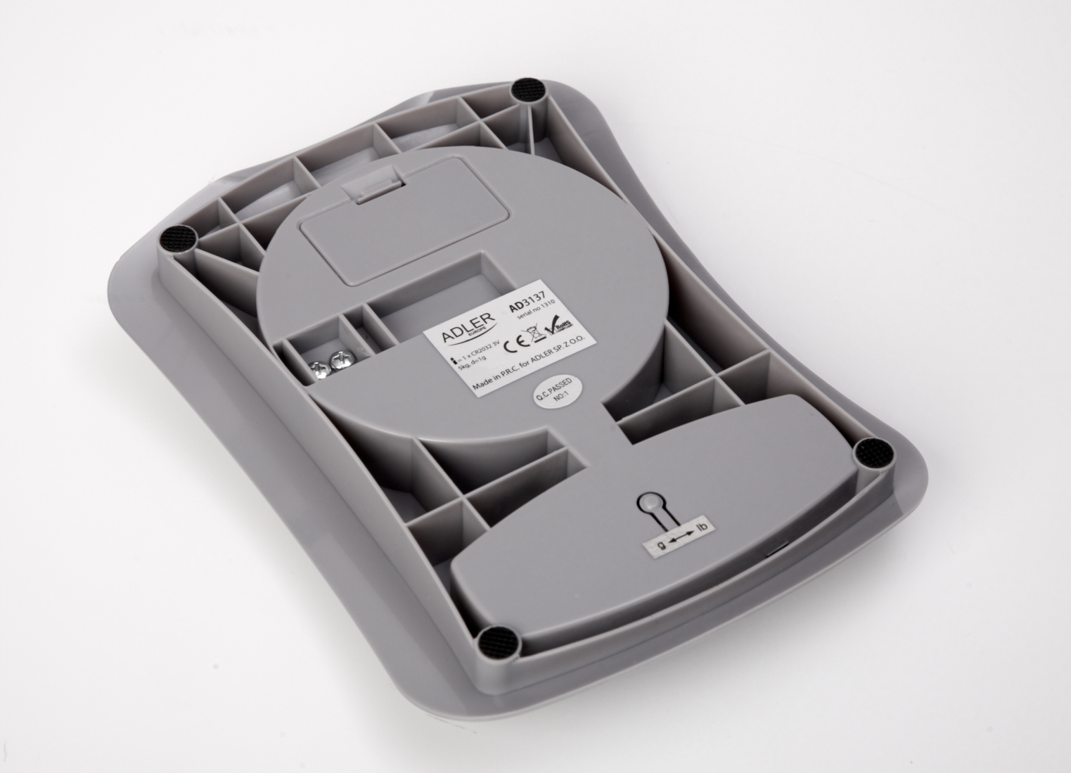 Spód szarej wagi z otworami wentylacyjnymi i komorą baterii.