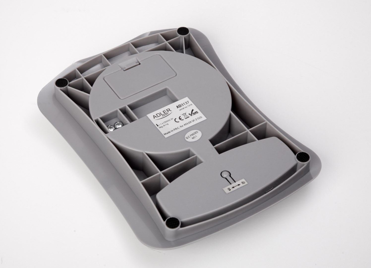 Spód szarej wagi ze etykietą, strukturą kratownicy i komorą baterii.