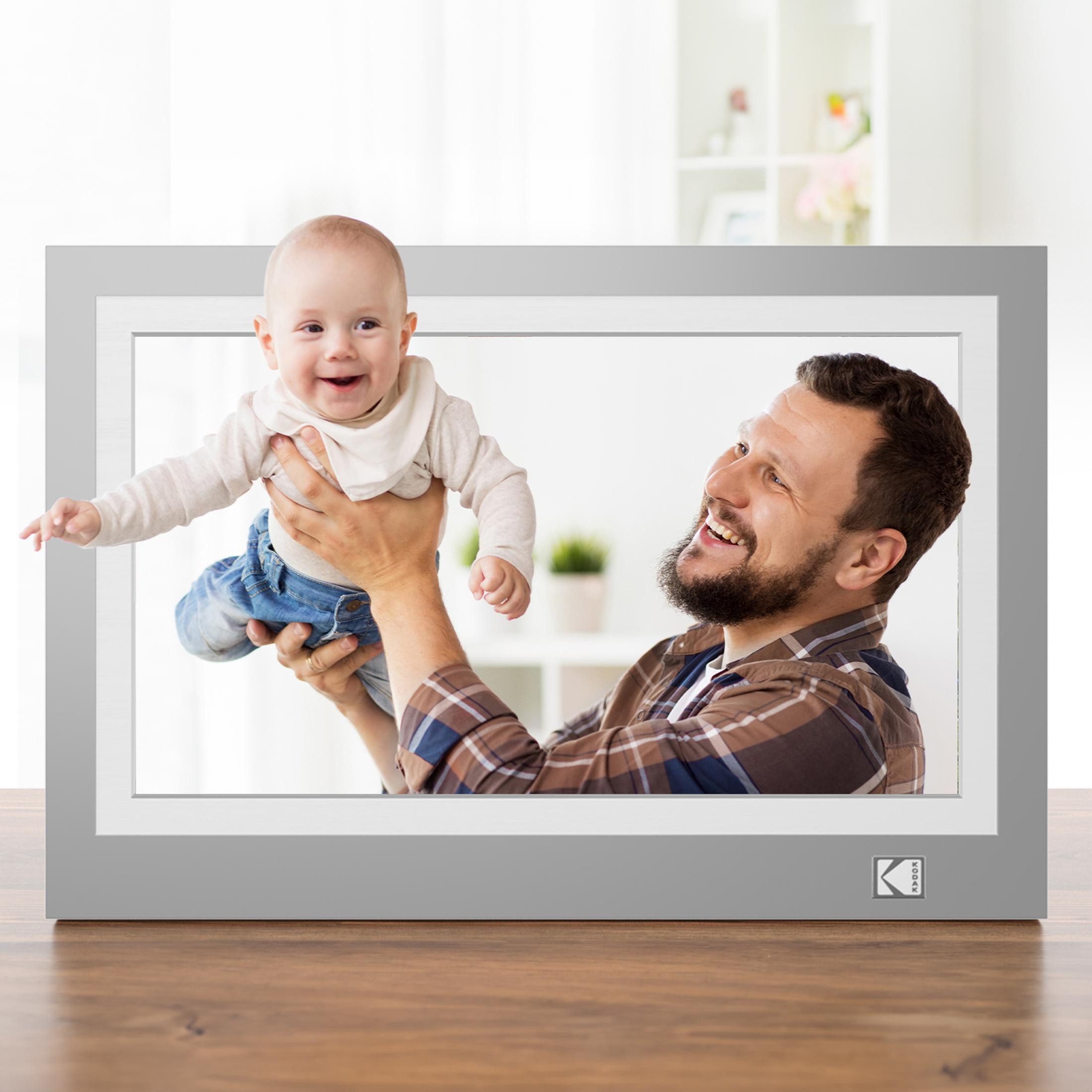 Ein lächelndes Baby wird von einem lachenden Mann in einem karierten Hemd hochgehalten, dargestellt in einem grauen digitalen Fotorahmen.
