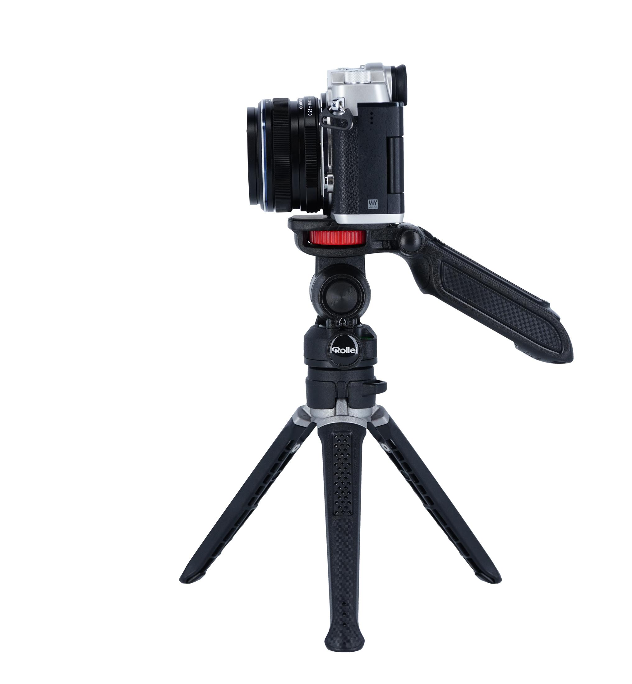 Piccola fotocamera argentata su treppiede Rollei nero con gambe piegate.