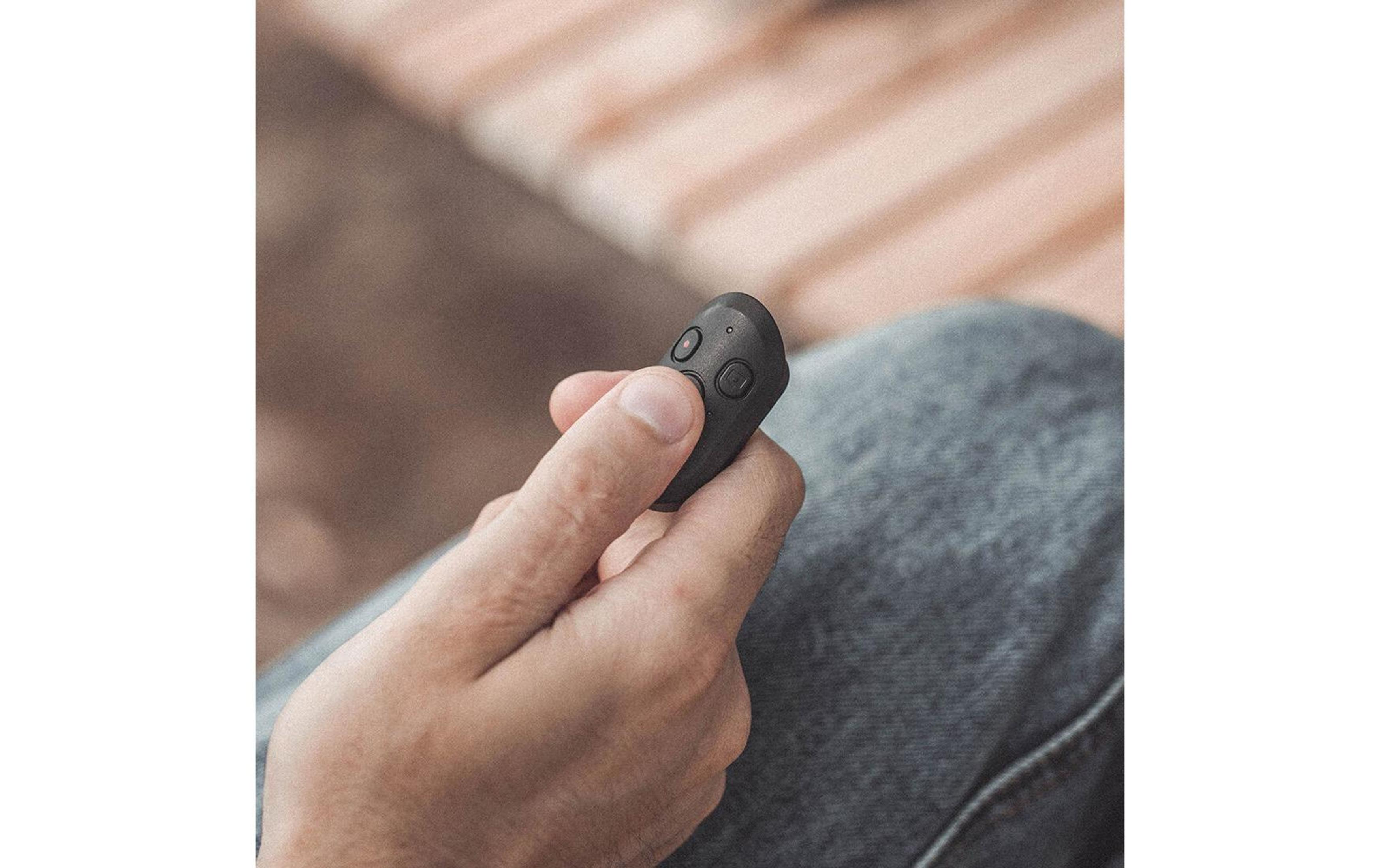 Personne tenant un porte-clés noir avec deux boutons dans la main.