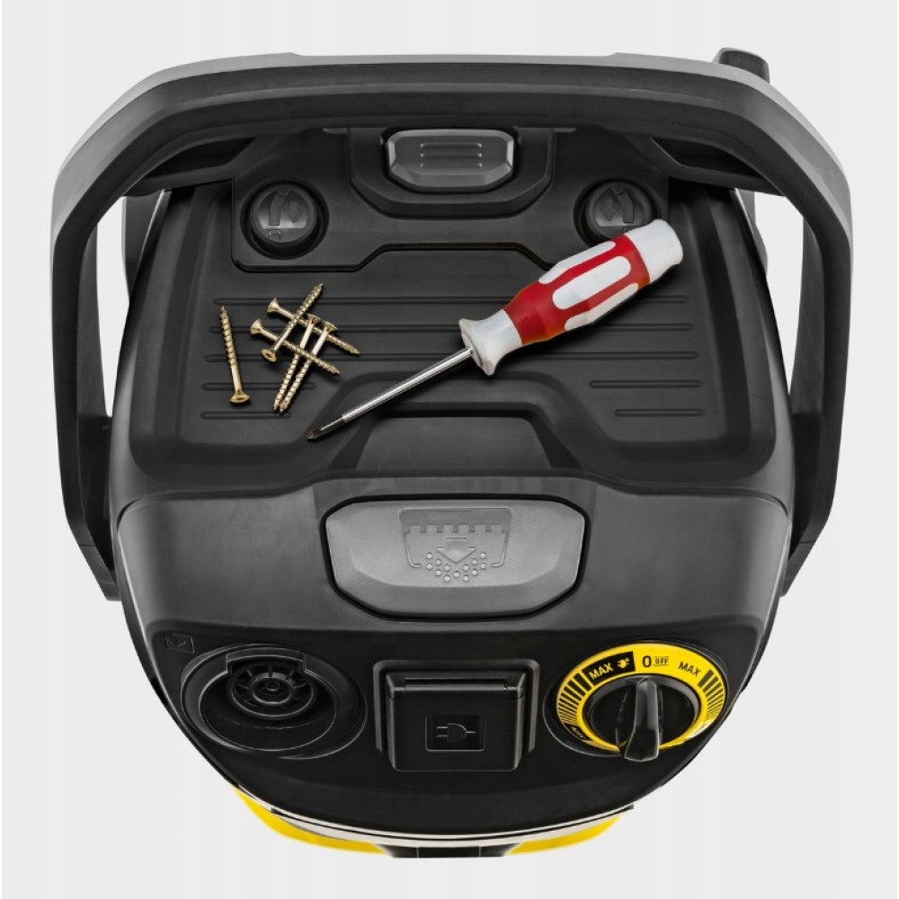 Śrubokręt i śruby na czarnej górnej części odkurzacza.