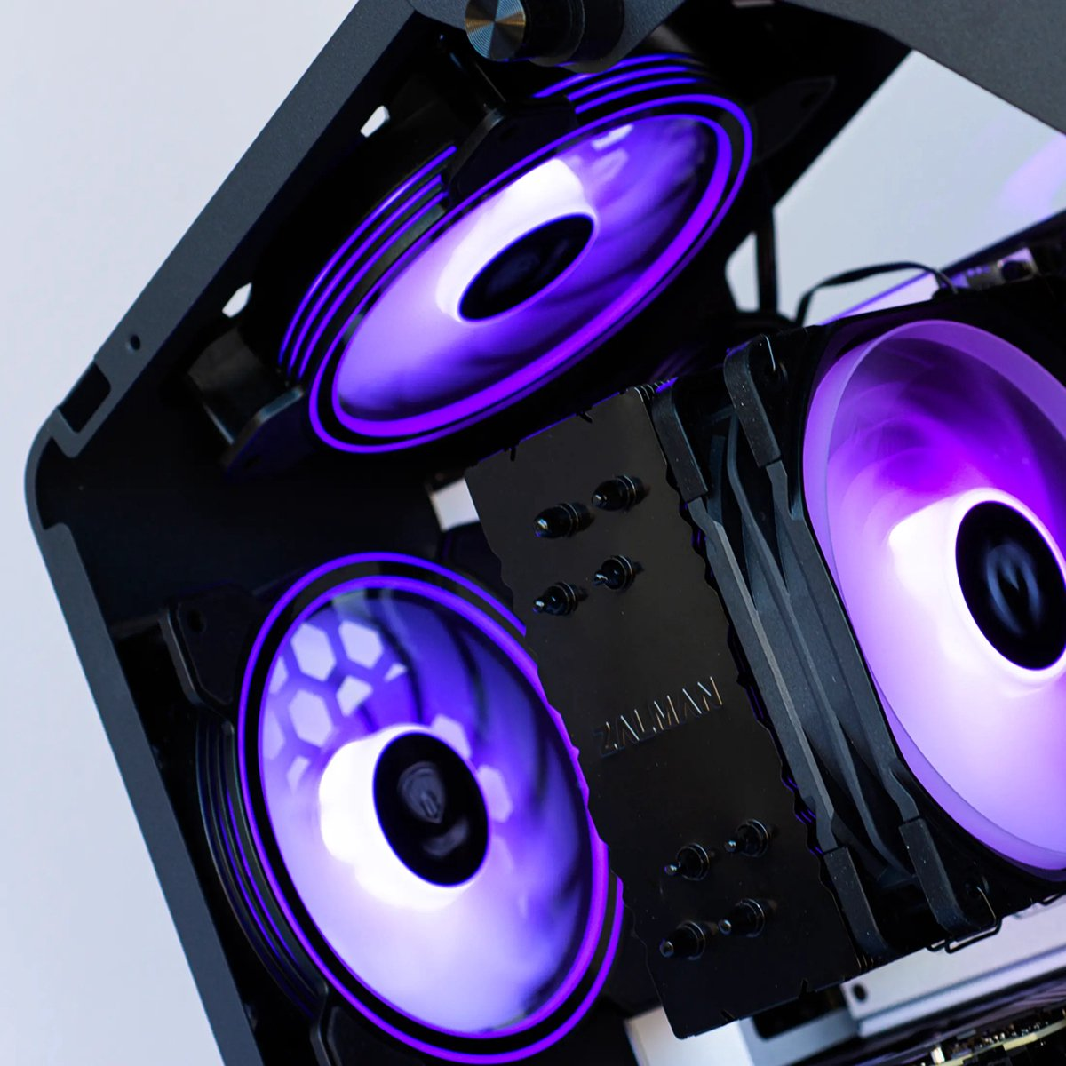 Three computer fans with purple lighting inside a computer case.