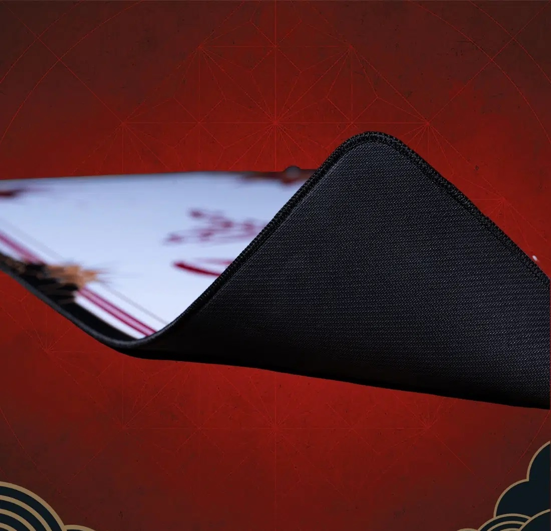 Zbliżenie zgiętego rogu podkładki pod mysz, ukazujące czarną gumową podeszwę.