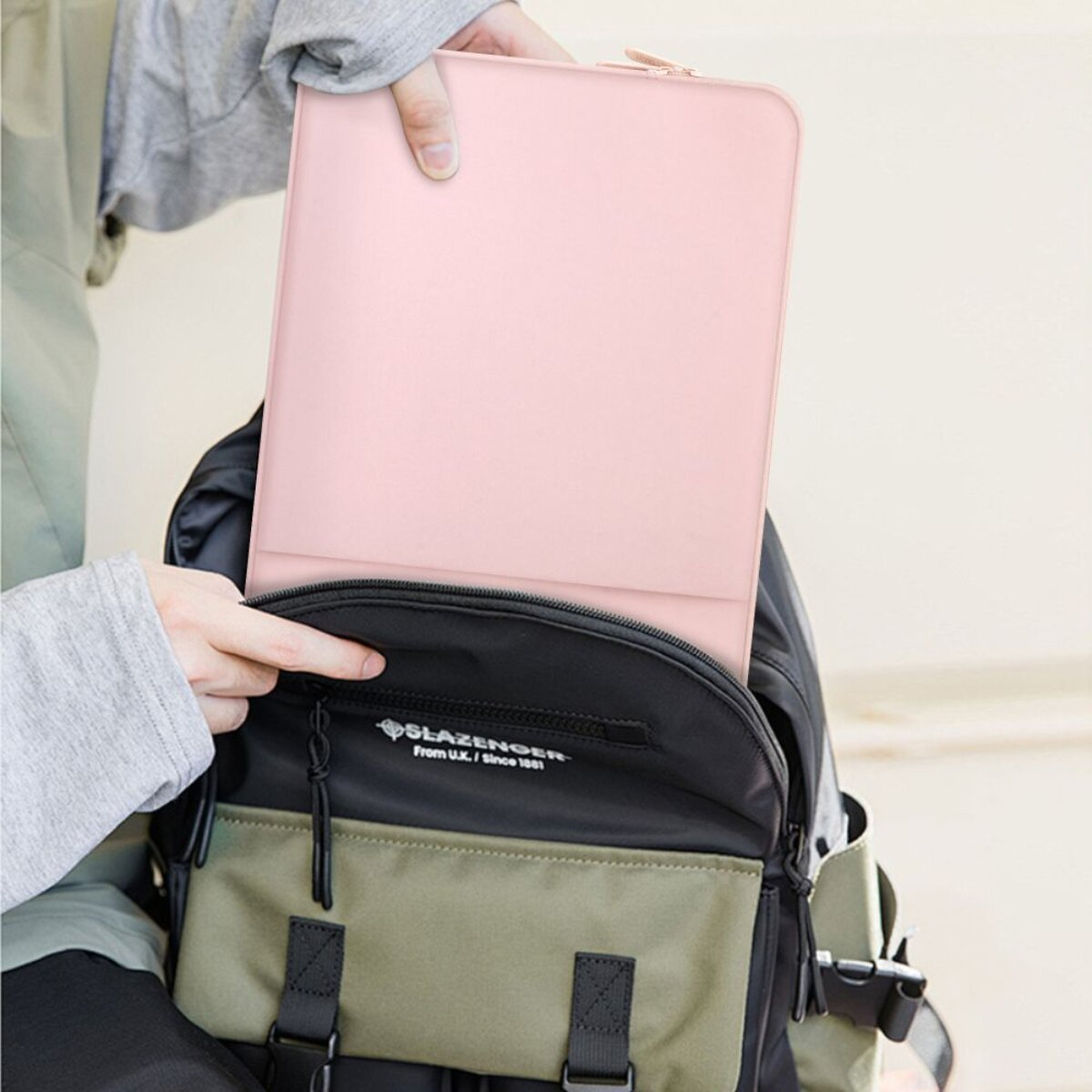 Eine Person packt eine rosafarbene Hülle in einen Rucksack.