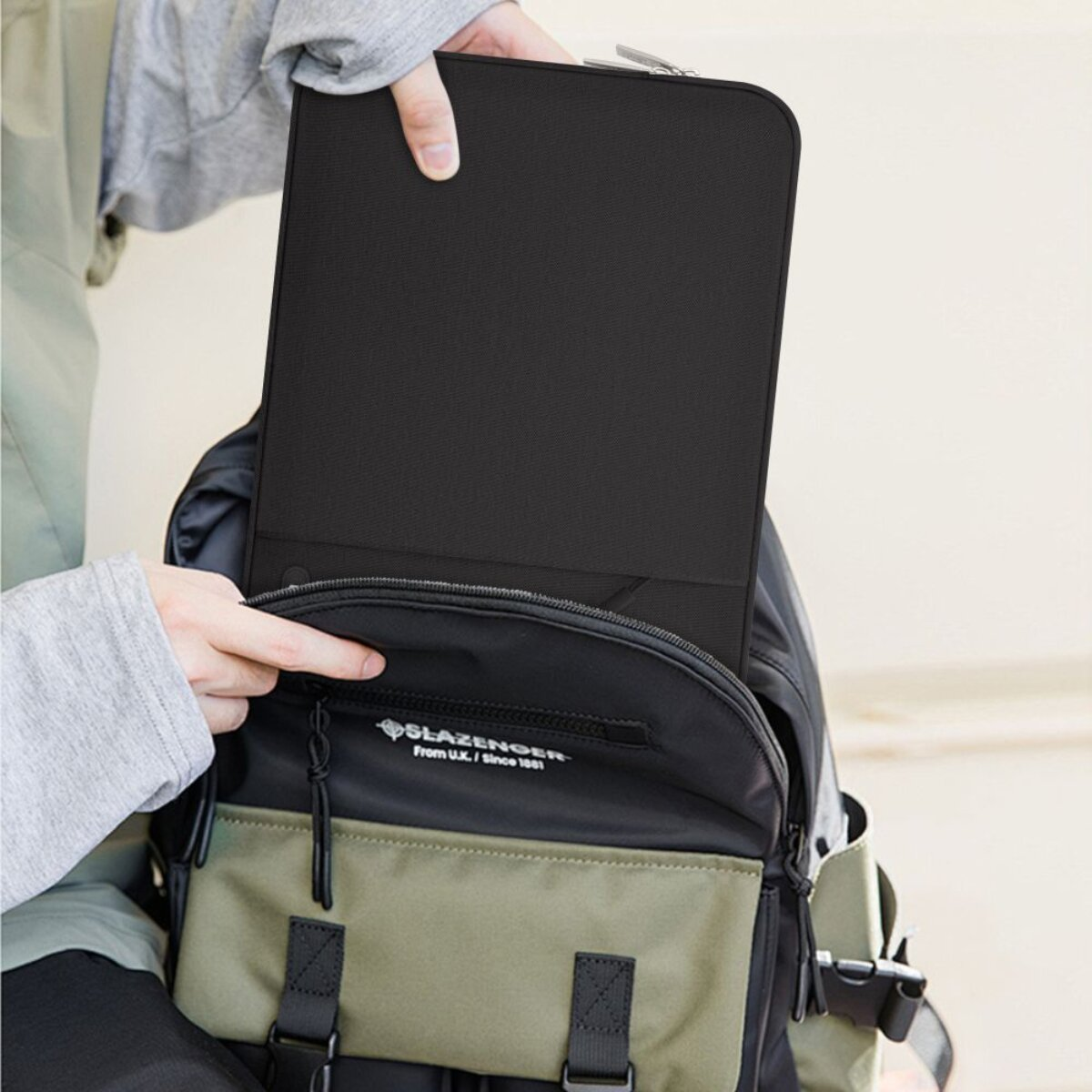 Person packt schwarzen Laptop-Hülle in Rucksack.