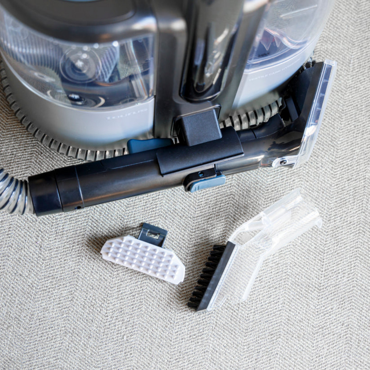 Zbliżenie węża odkurzacza i akcesoriów na dywanie.