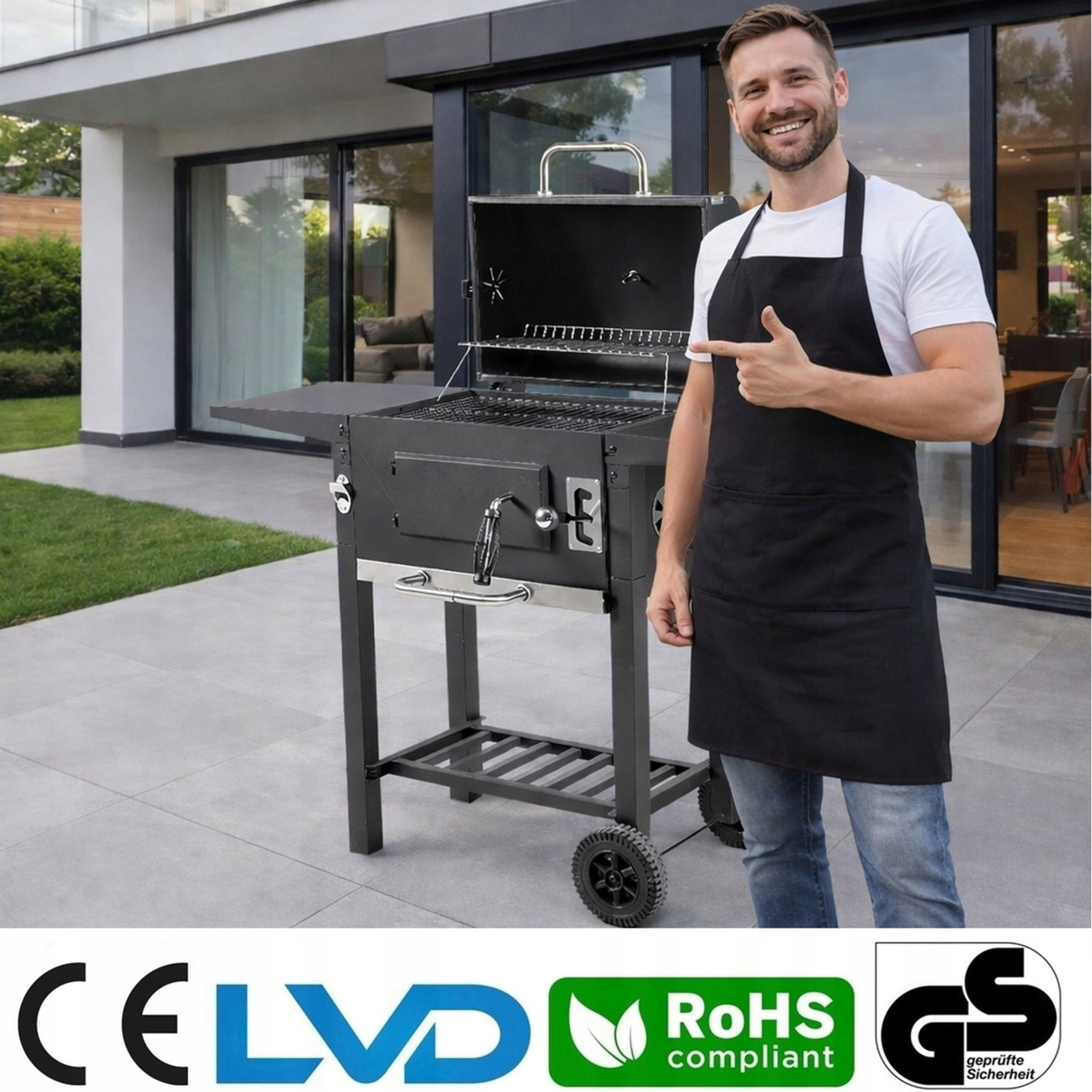 Mężczyzna w fartuchu grillowym wskazuje na grill węglowy na tarasie.