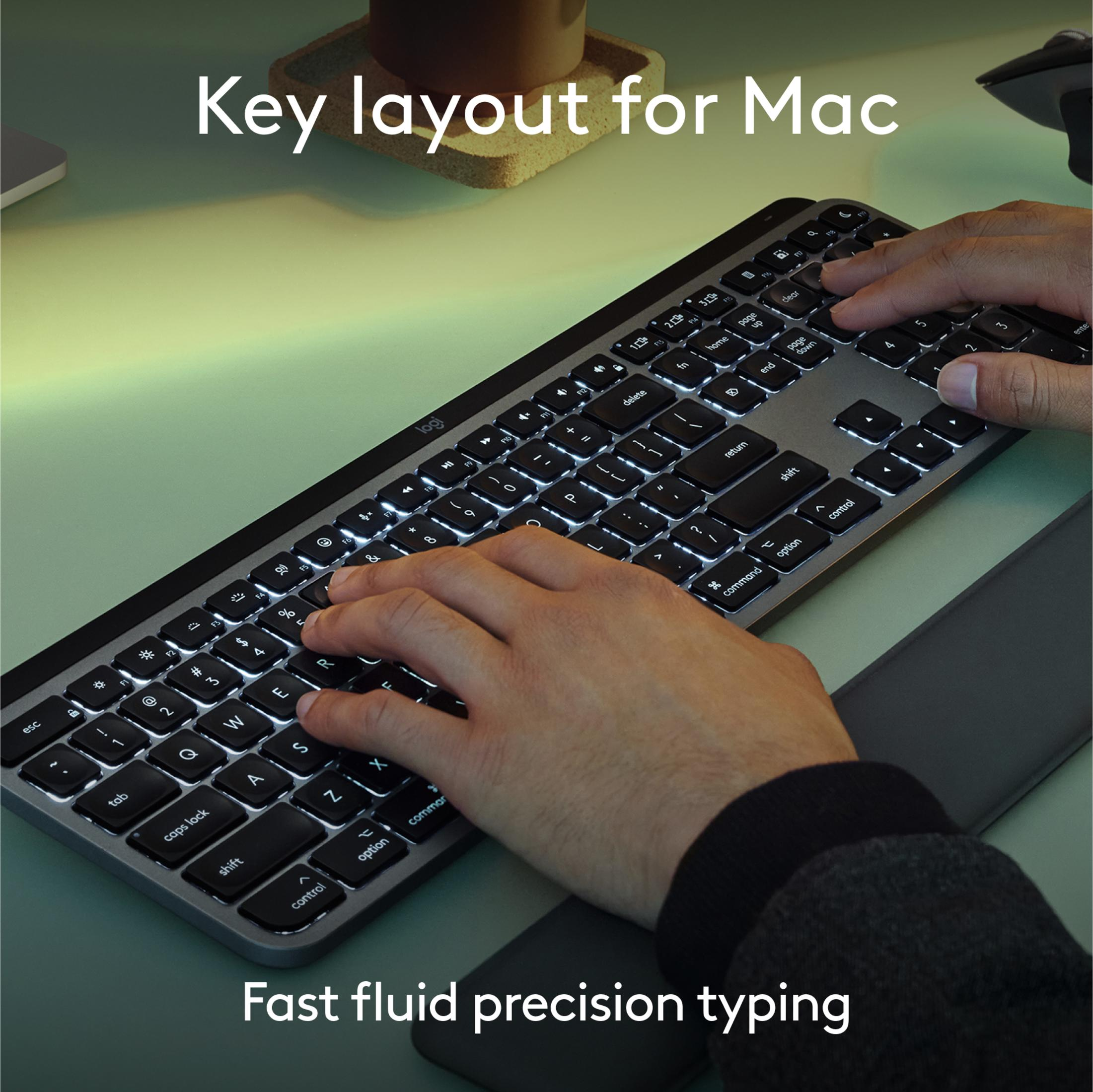 Mani che digitano su una tastiera Mac retroilluminata. Vista ravvicinata.