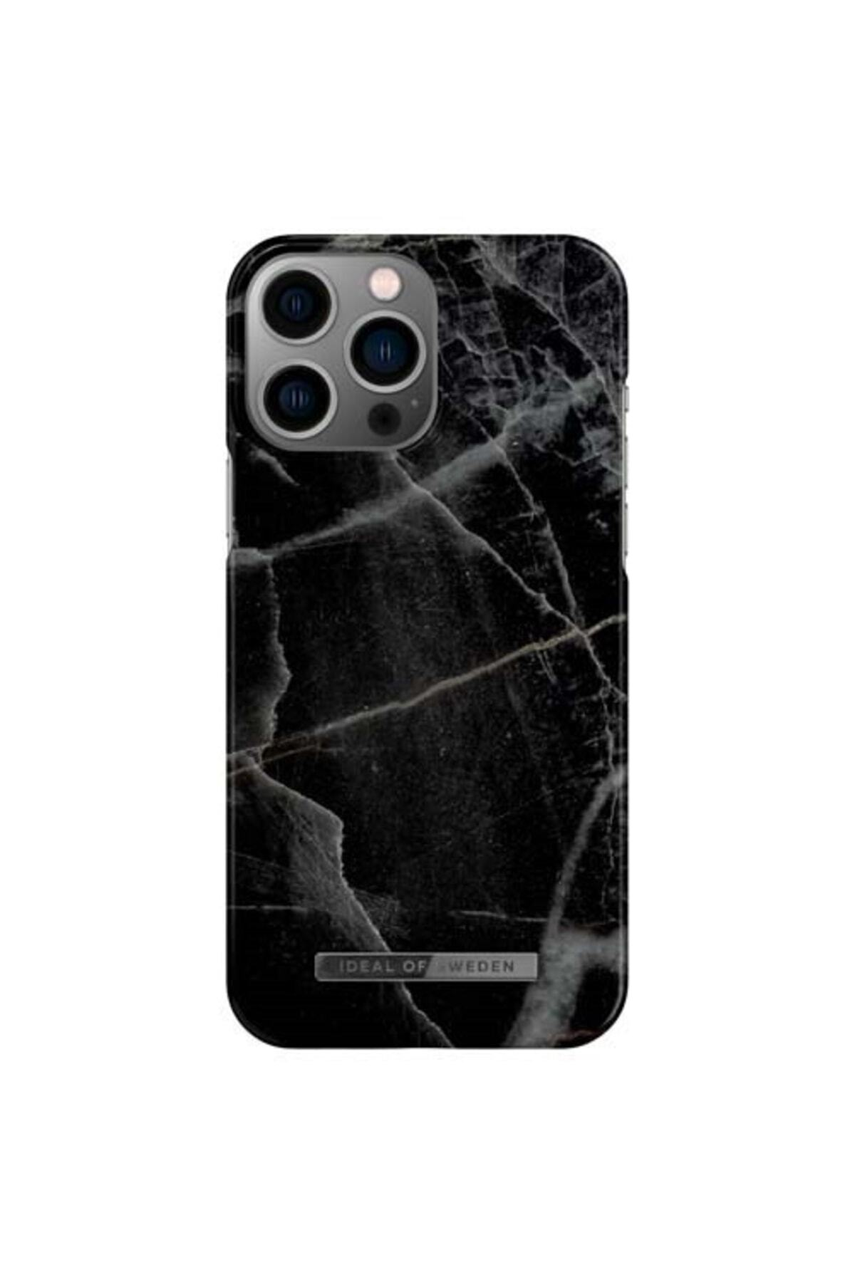 Üstte üç kamera lensi olan, mermer desenli siyah bir telefon.