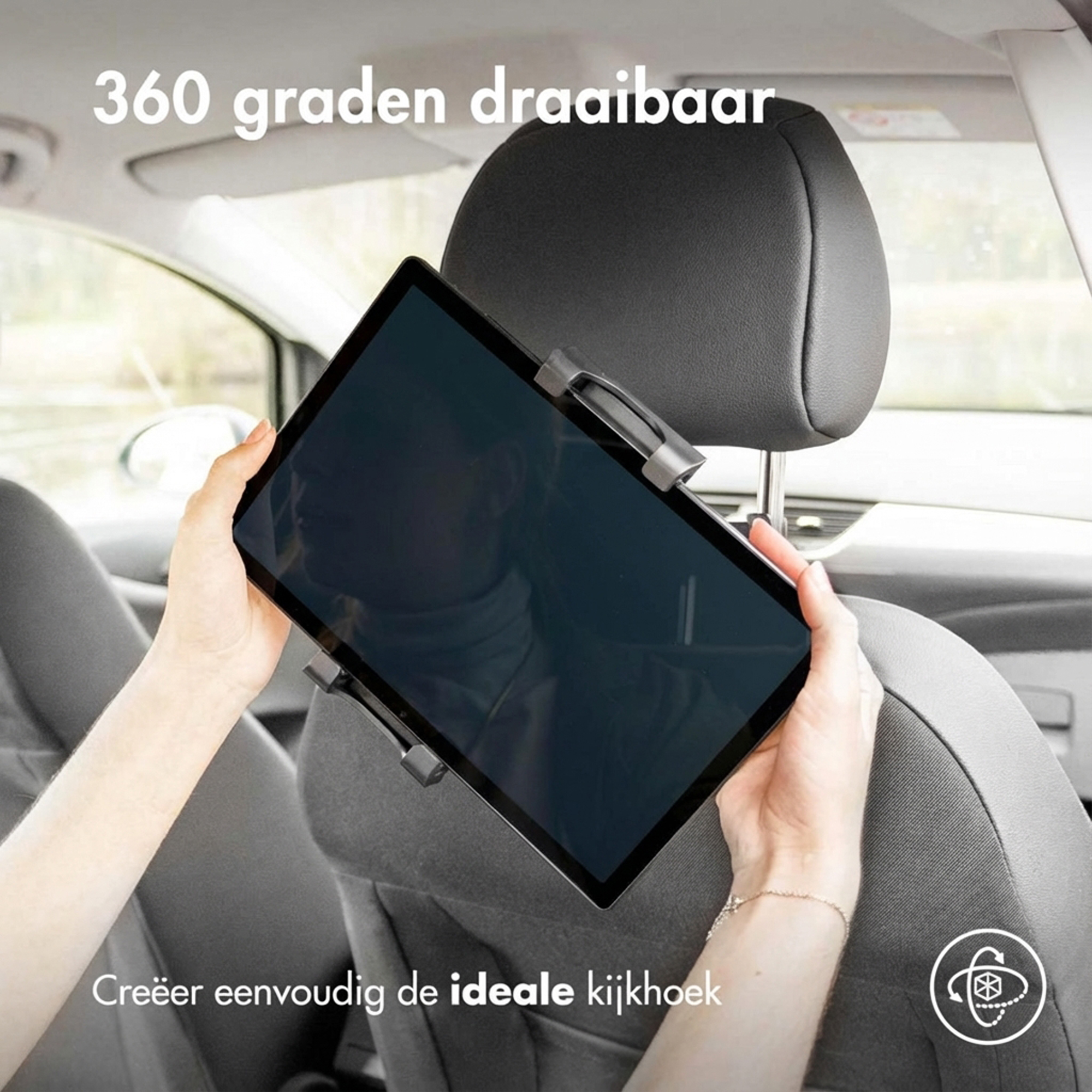 A person holds a tablet in a car, attached to a headrest.