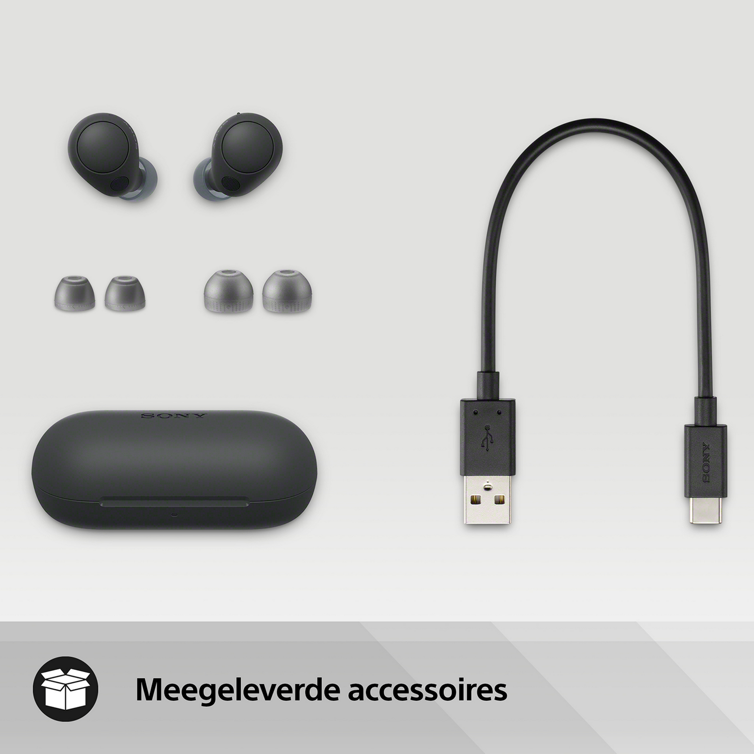 Auriculares Sony negros, estuche de carga, almohadillas y cable USB sobre fondo gris.