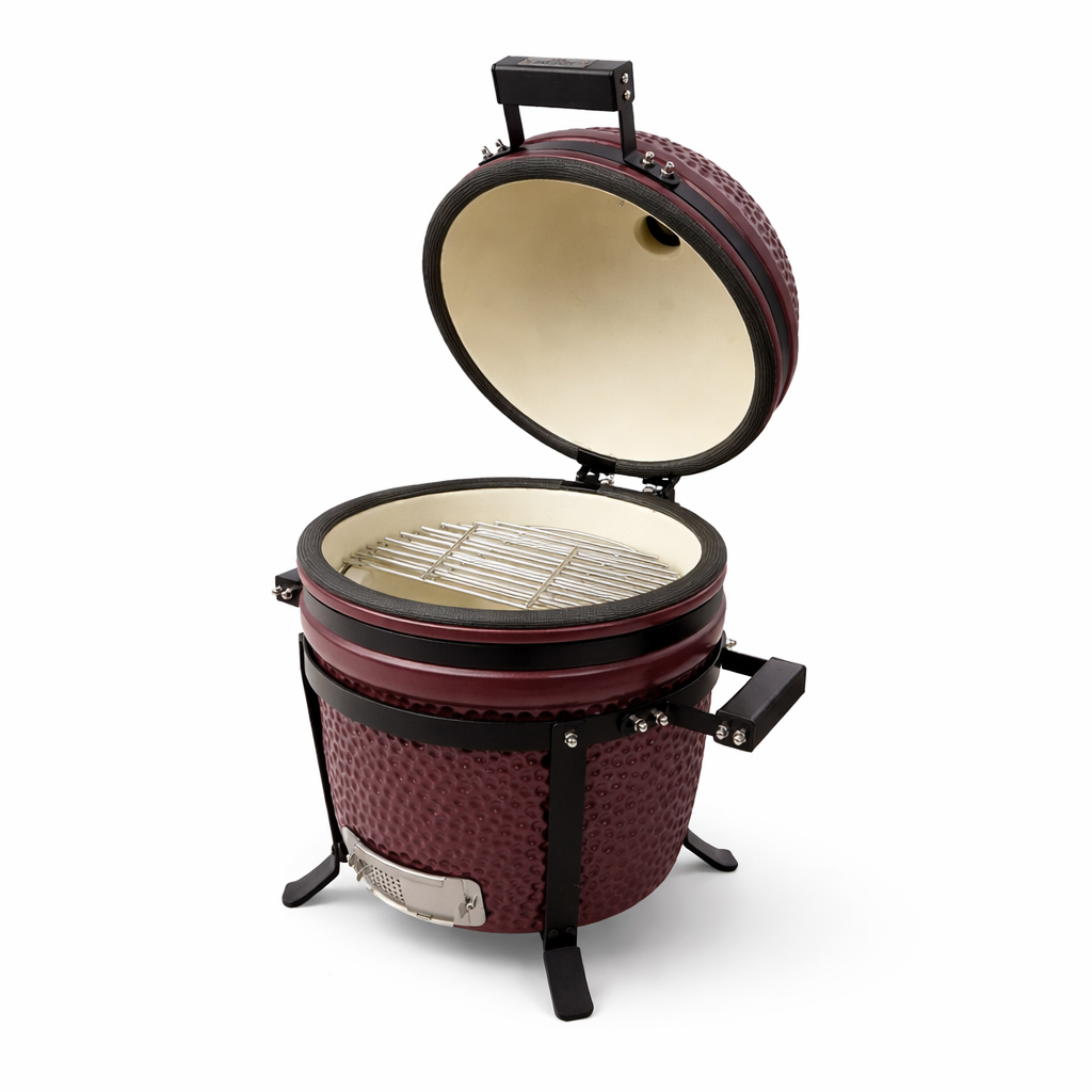 Ein maroonfarbener Kamado-Grill mit strukturierter Oberfläche und schwarzer Zierleiste, mit offenem Deckel, der ein weißes Inneres und einen Metallrost zeigt.