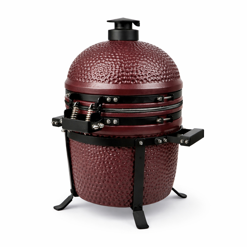 Ein burgunderroter Keramikgrill mit Hammerschlagmuster und schwarzen Metallteilen.