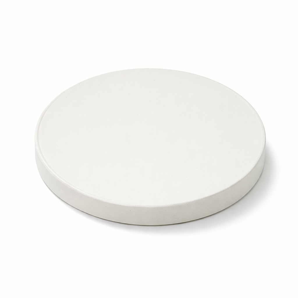 Een witte, ronde schotel met een lichte rand op een witte achtergrond.