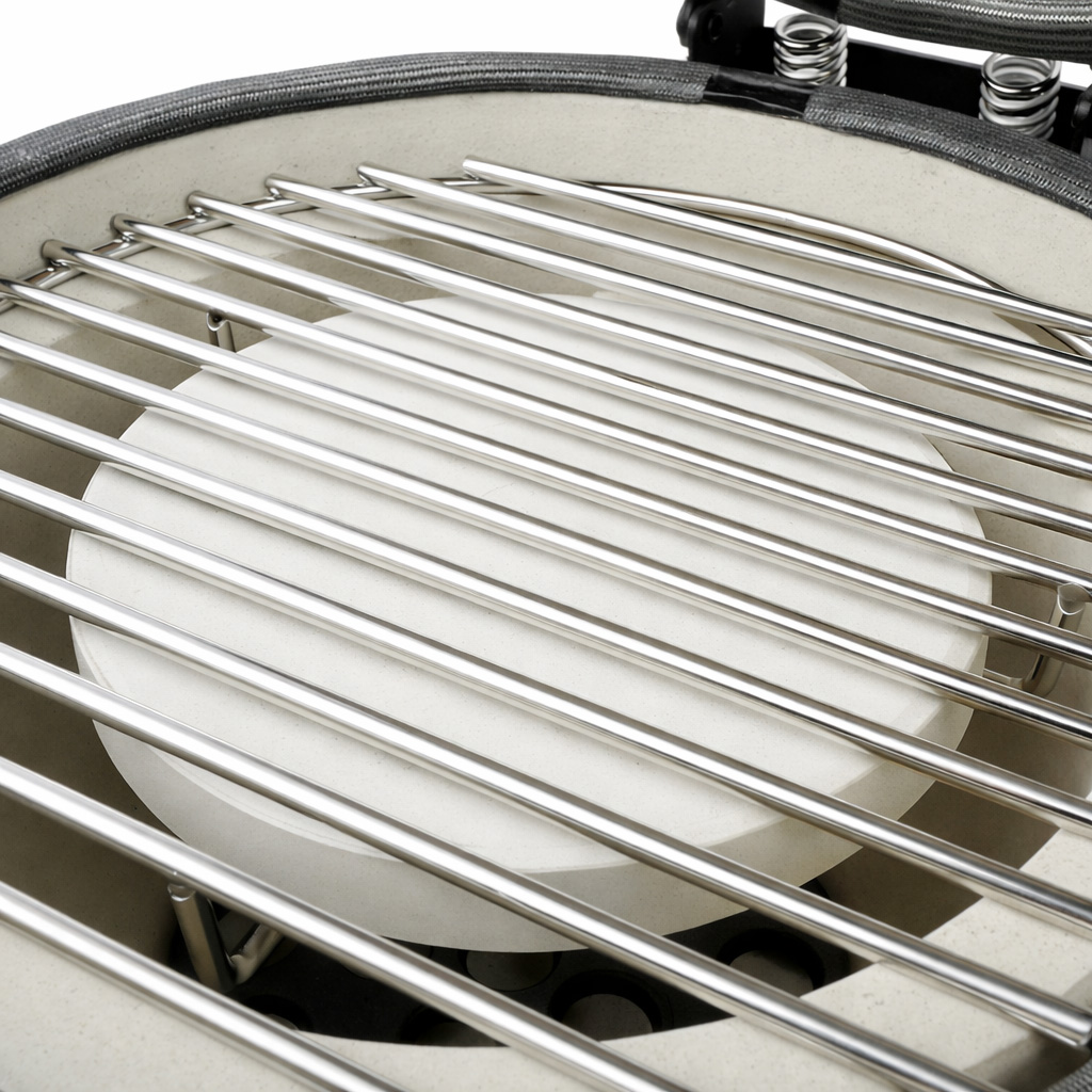 Close-up van een metalen grillrooster boven een witte keramische steen binnenin.