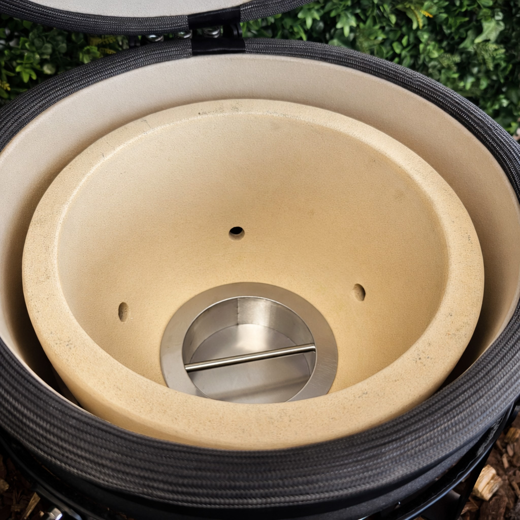 Keramikgrill mit offenem Deckel, beige Innenschale, Metallzubehör.