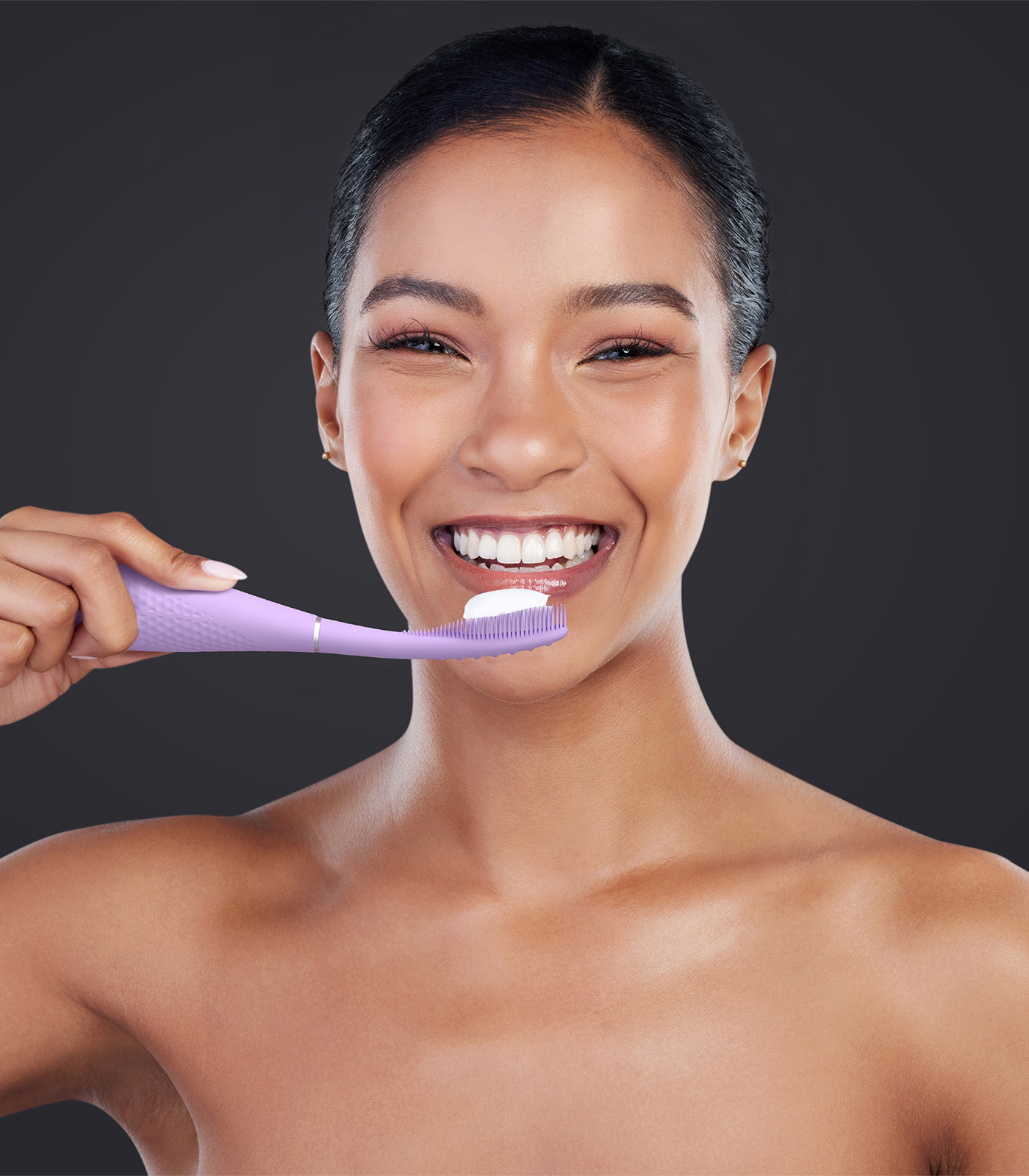 Donna sorridente con spazzolino viola chiaro e dentifricio bianco.