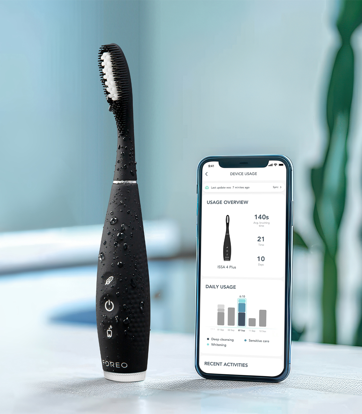 Uno spazzolino nero con gocce d'acqua accanto a uno smartphone che mostra i dati dell'app.